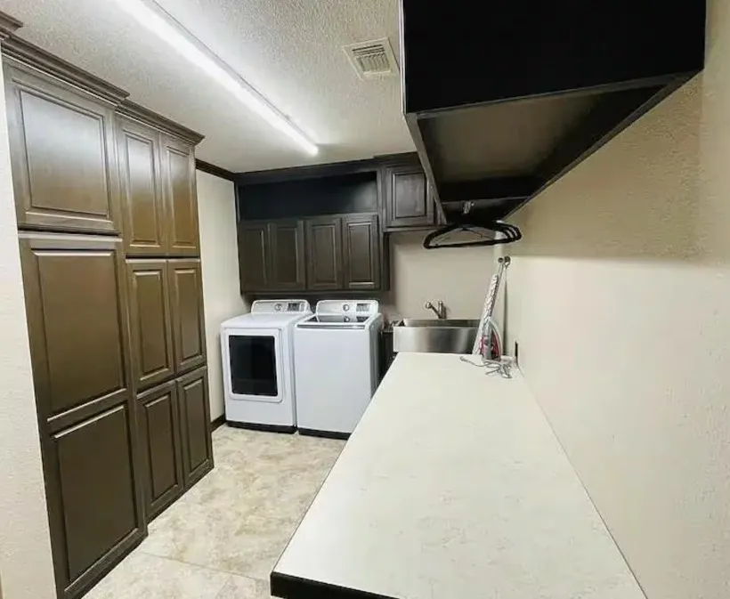 Extensive cabinetry storage, integrated sink, overhead shelving, and a dedicated countertop workspace