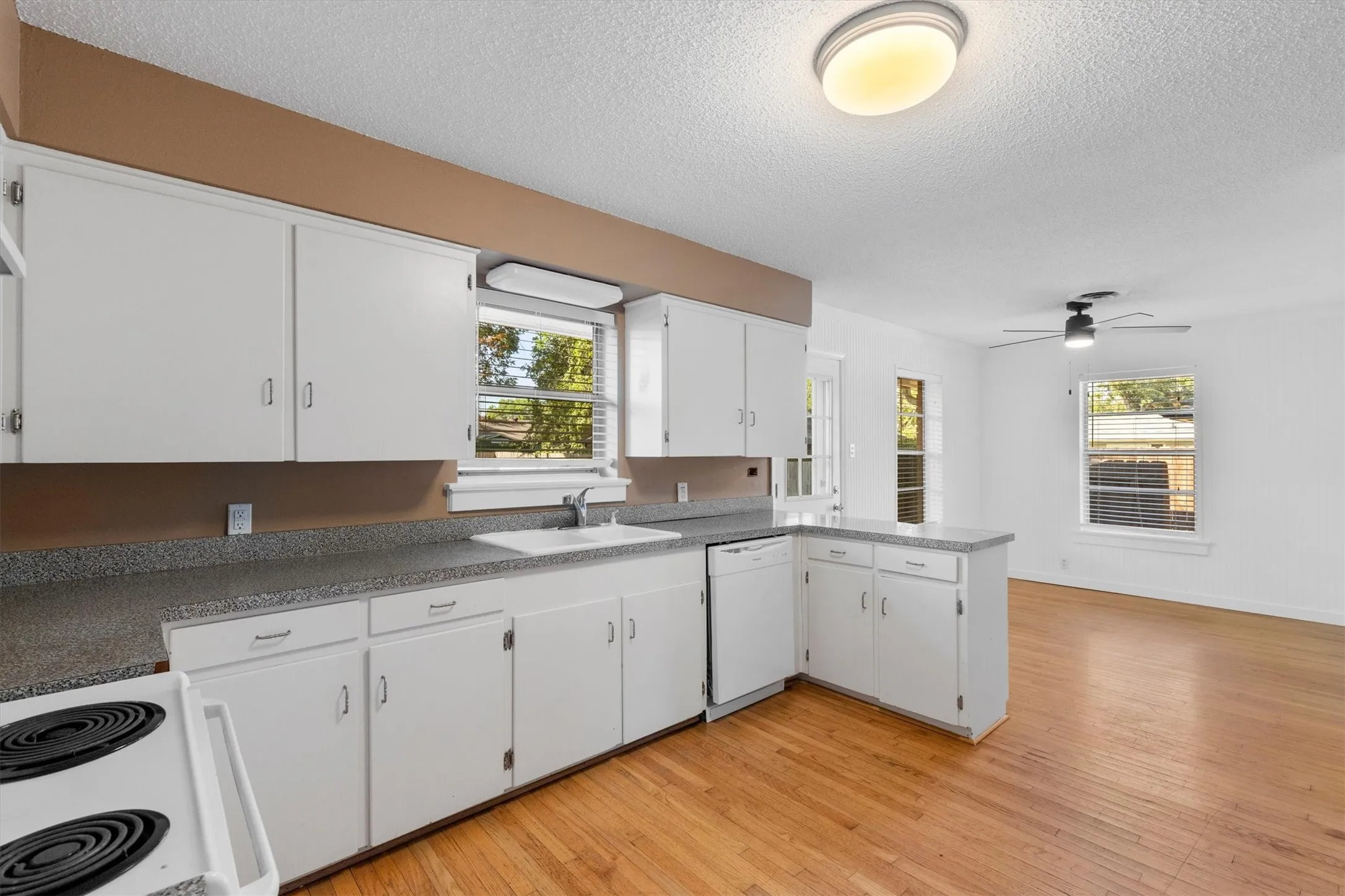 Kitchen featuring white cabinetry, a built-in dishwasher, and a laminate countertop