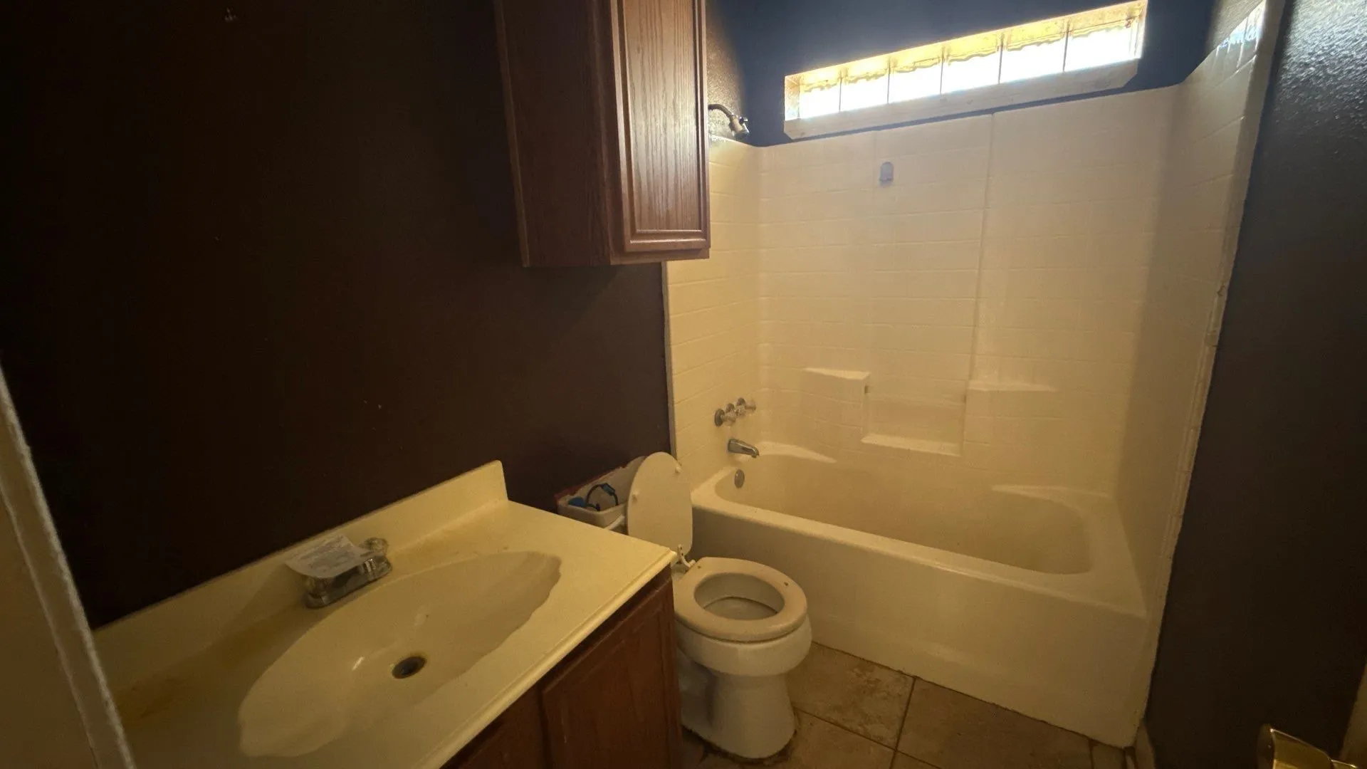Secondary Bathroom featuring a built-in vanity with integrated sink, wood-finish cabinetry, a white tub, and a toilet