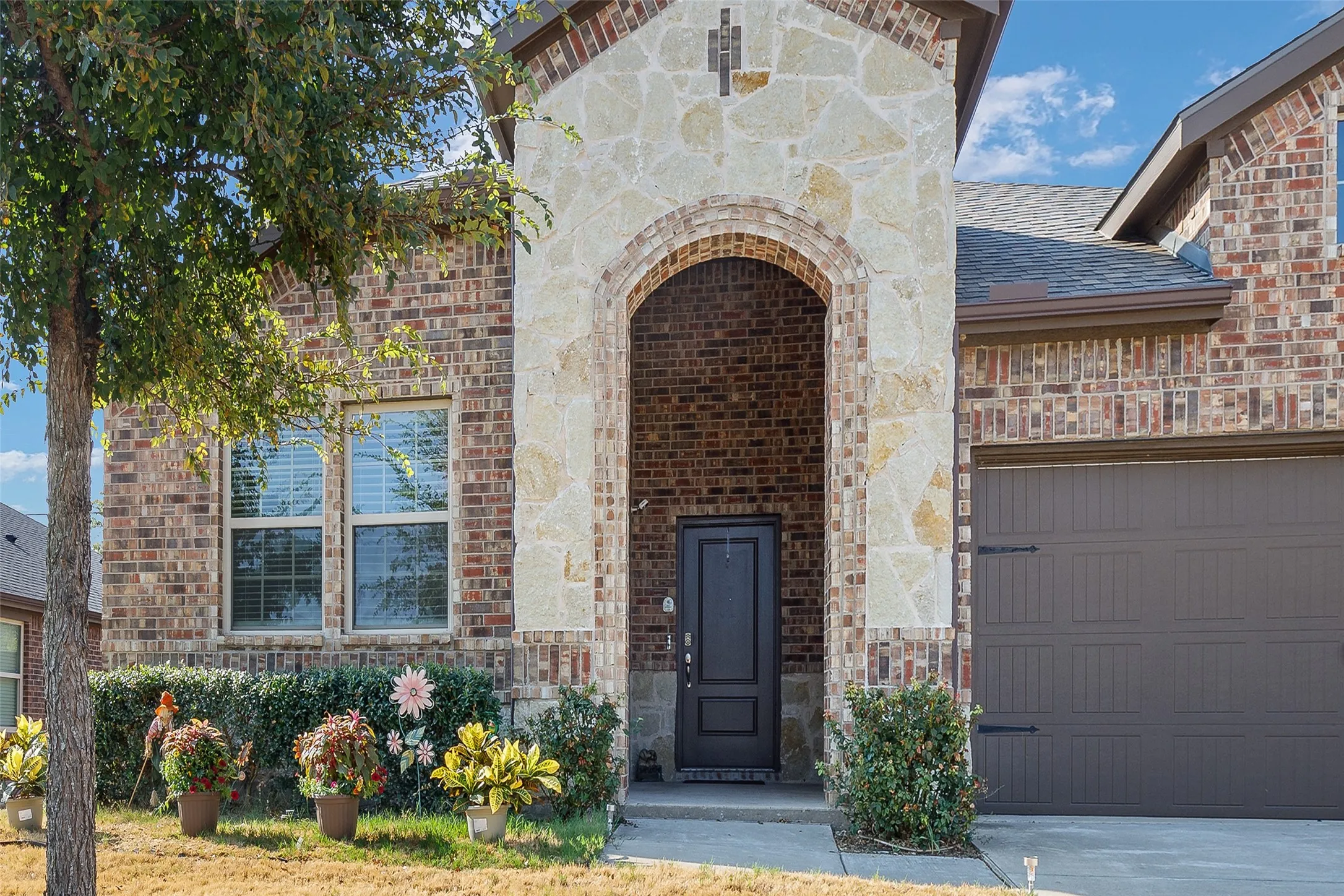 Brick and stone facade featuring an arched entryway