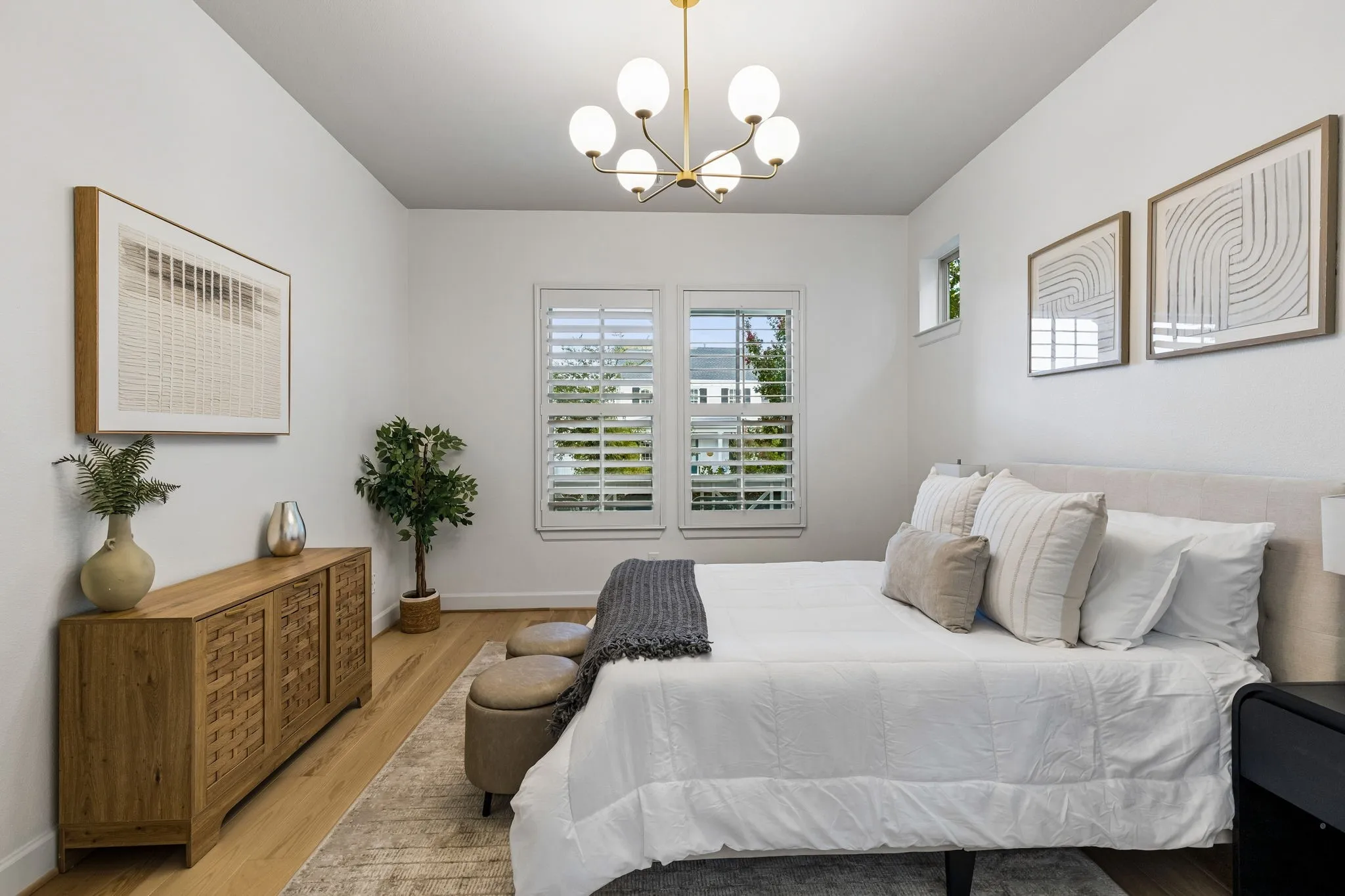 Hardwood-finish flooring, white walls, and a contemporary chandelier