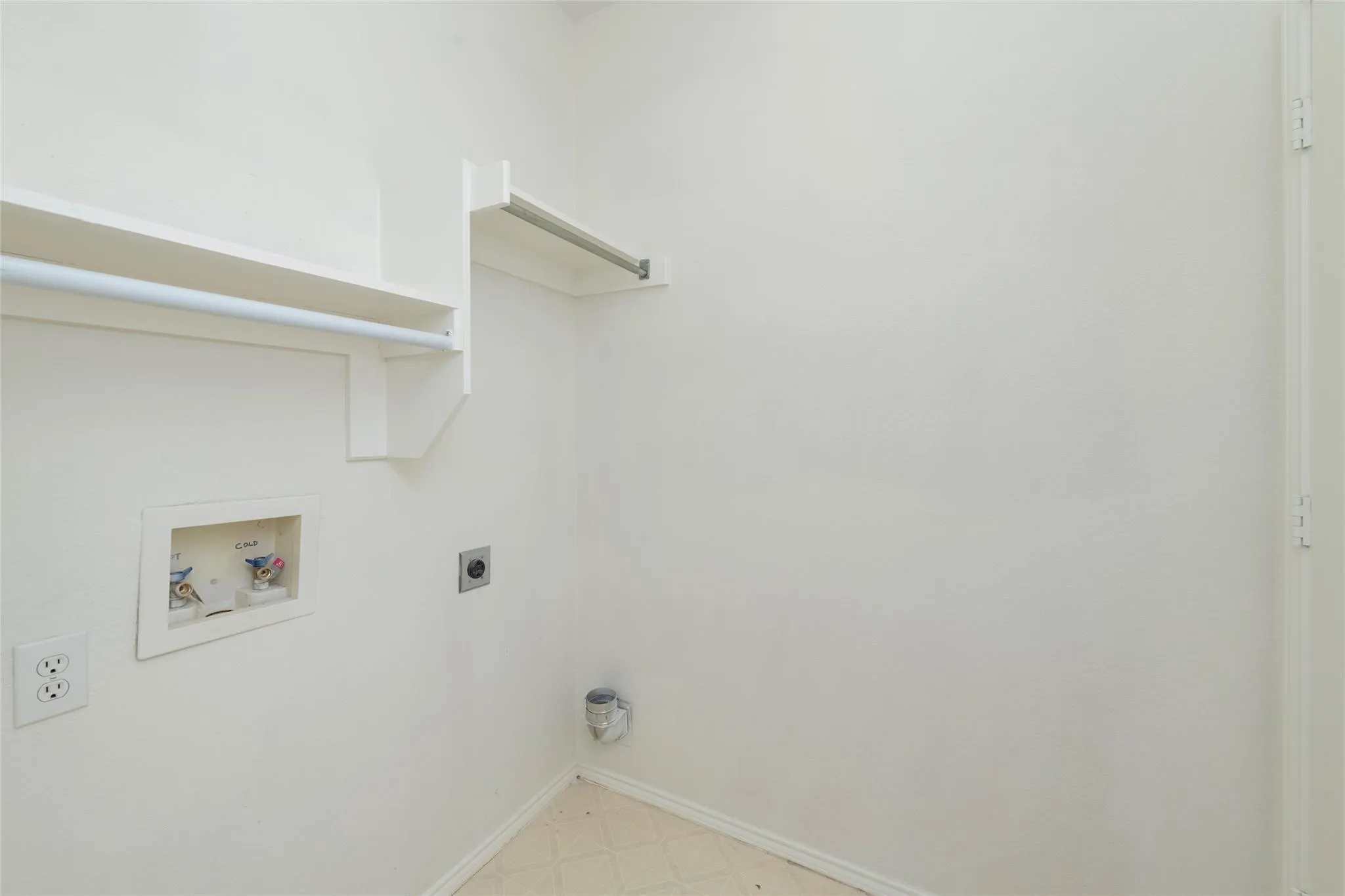 Laundry area featuring a utility sink connection, built-in shelving, and a hanging rod