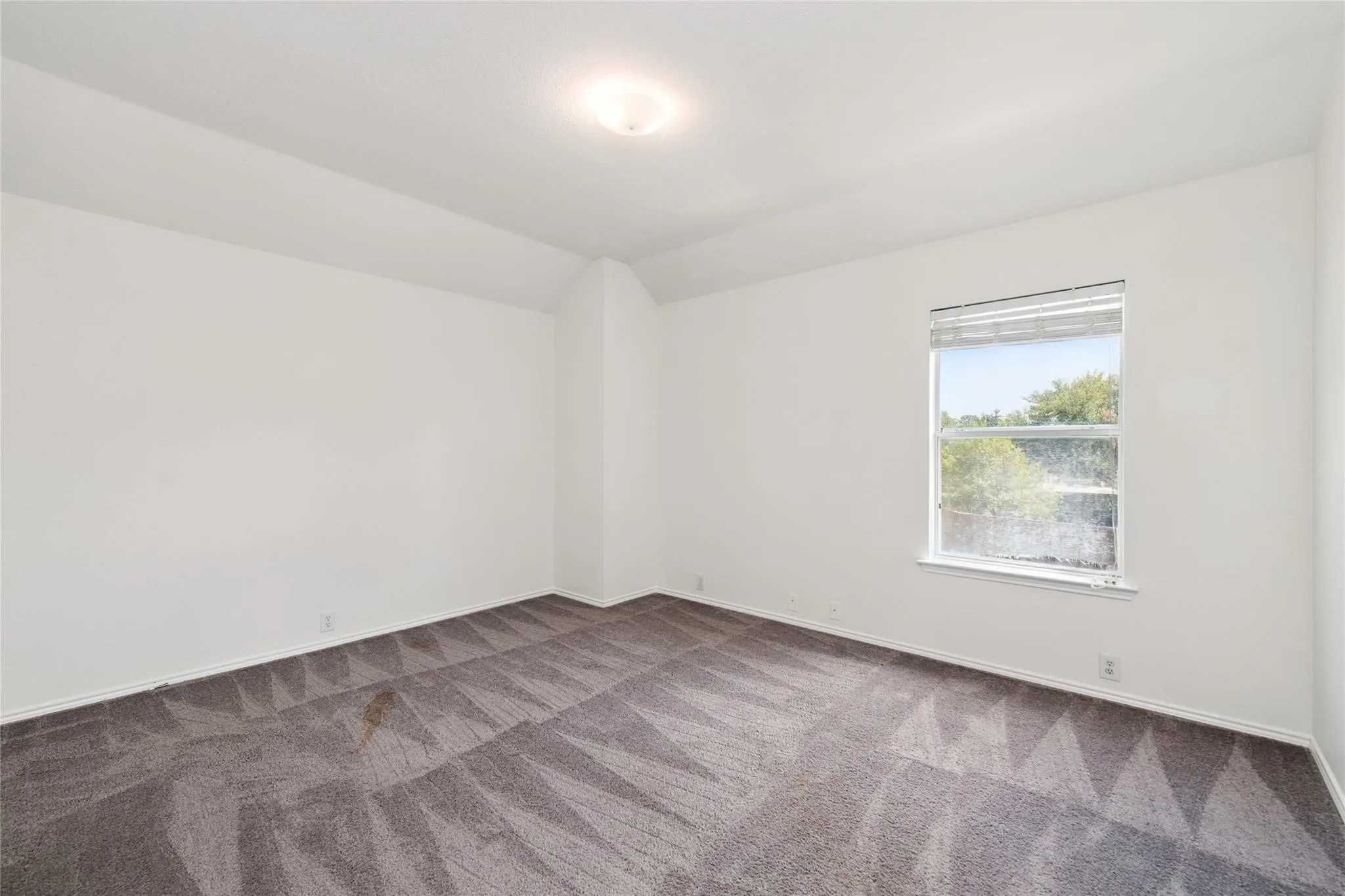 Recessed ceiling light fixture, framed window, and patterned carpet