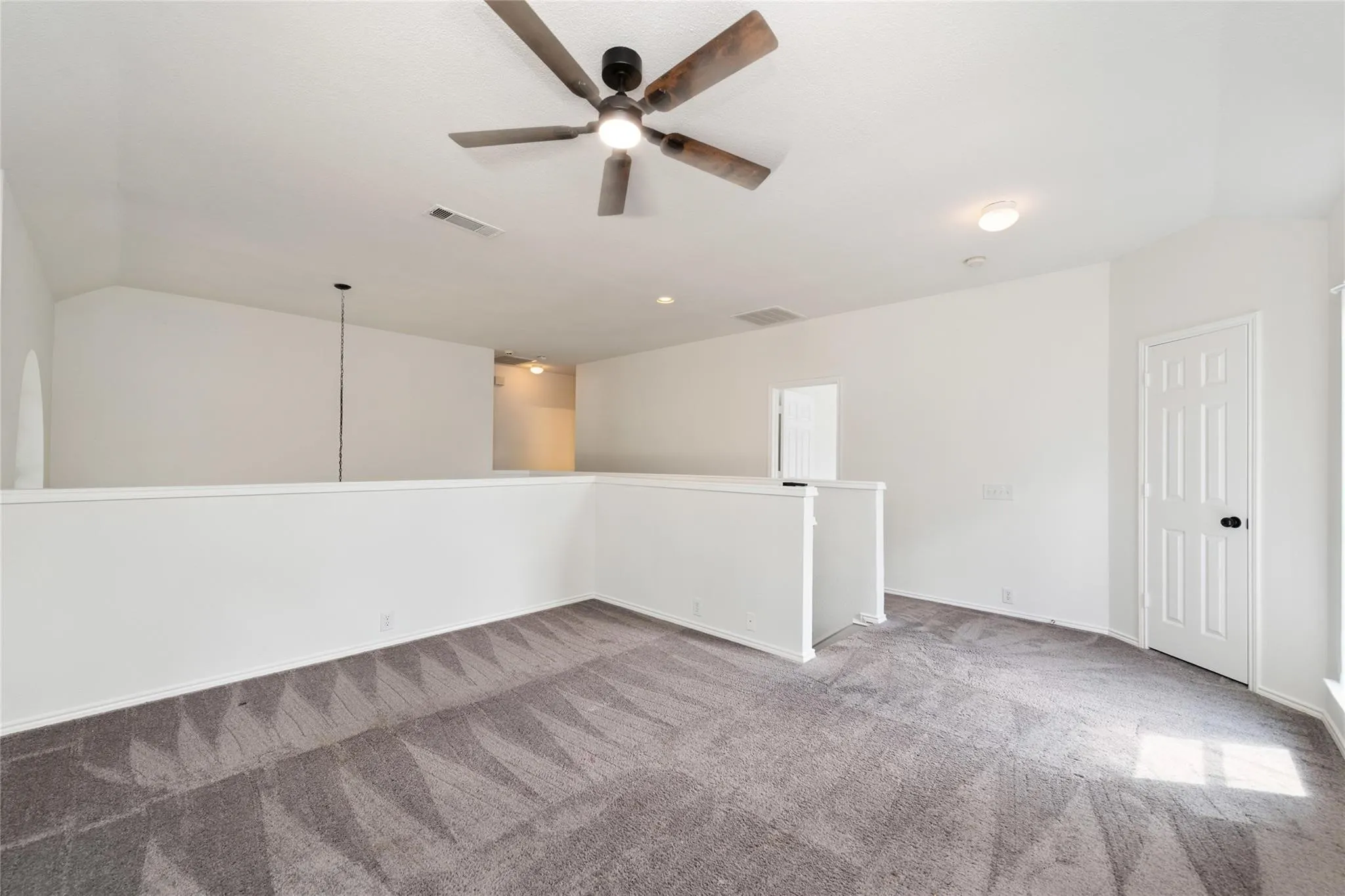 Open landing area featuring patterned carpet flooring, a ceiling fan, and recessed lighting