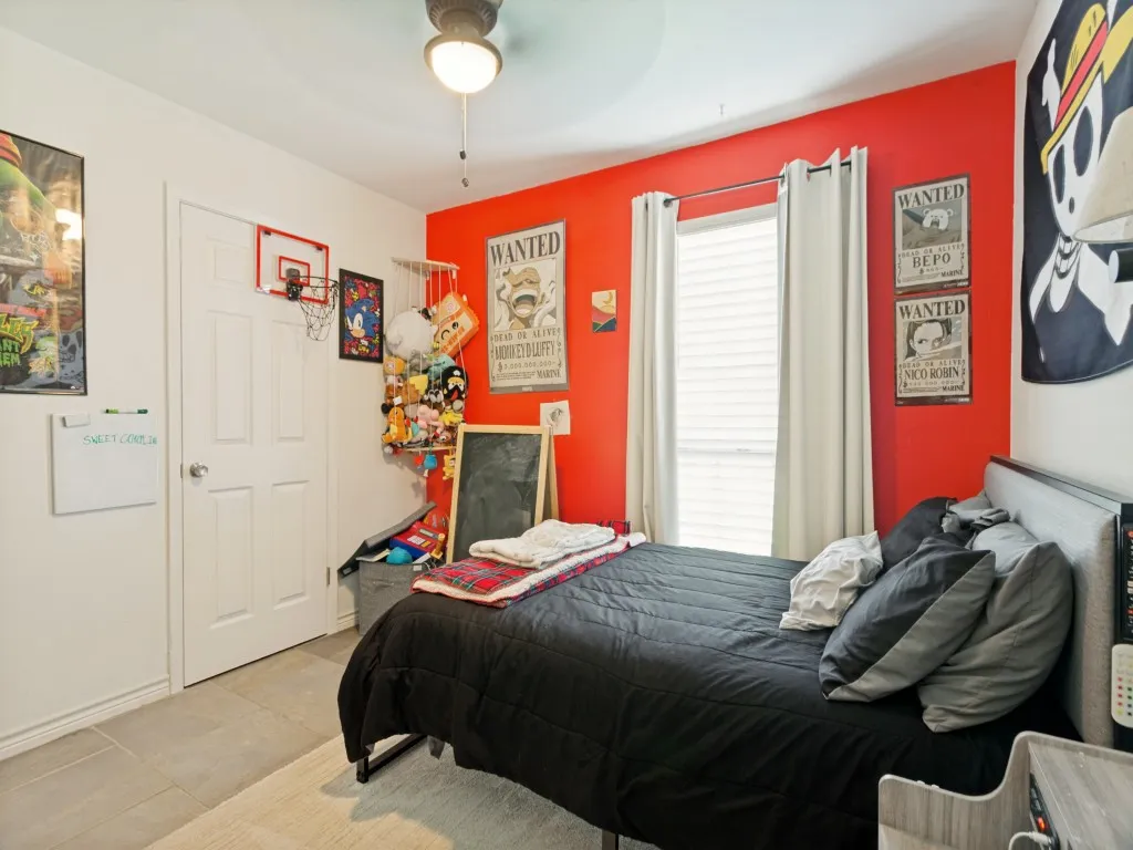 Recessed window with blinds, ceiling fan with integrated lighting, paneled interior door, and tile flooring