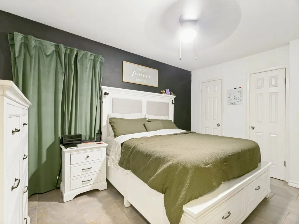 Tile flooring, ceiling fan, and painted accent wall