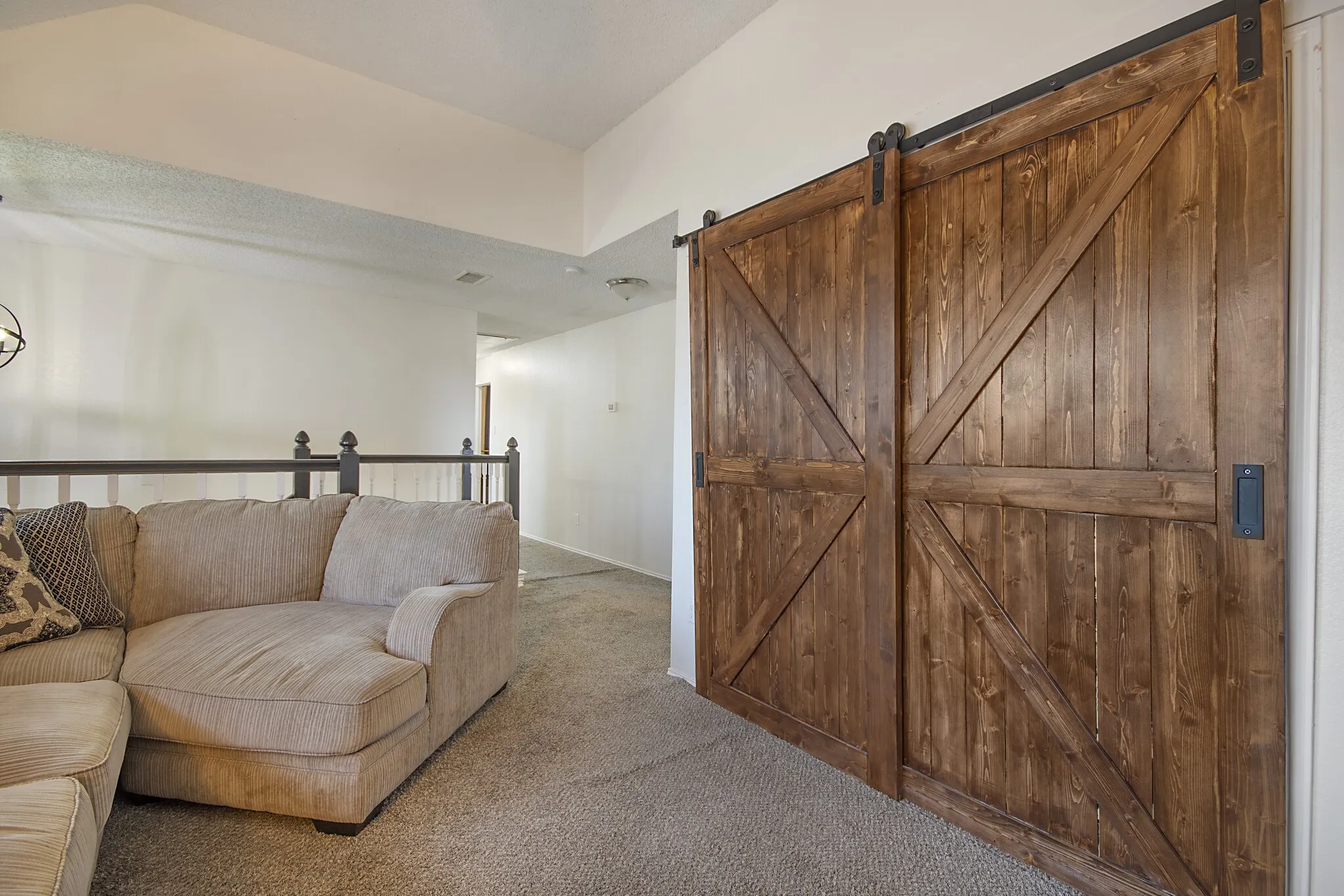 Upstairs loft living area behind a sliding barn door.