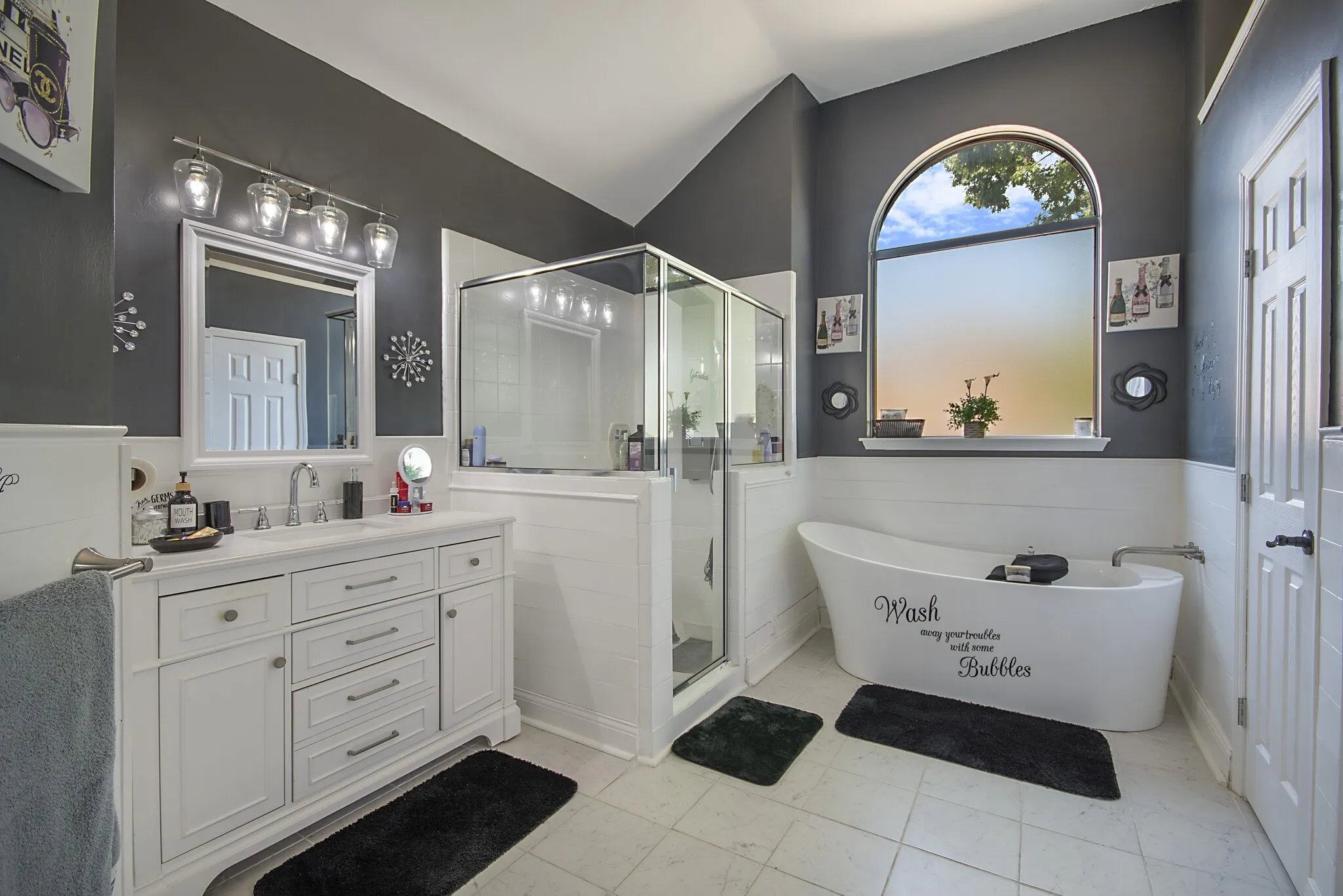 Primary bath with double vanity, separate glass shower and soaking tub.