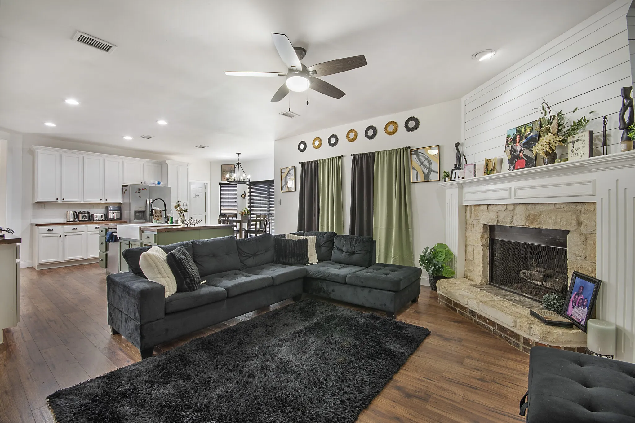 Family room with a stone fireplace and shiplap surround.