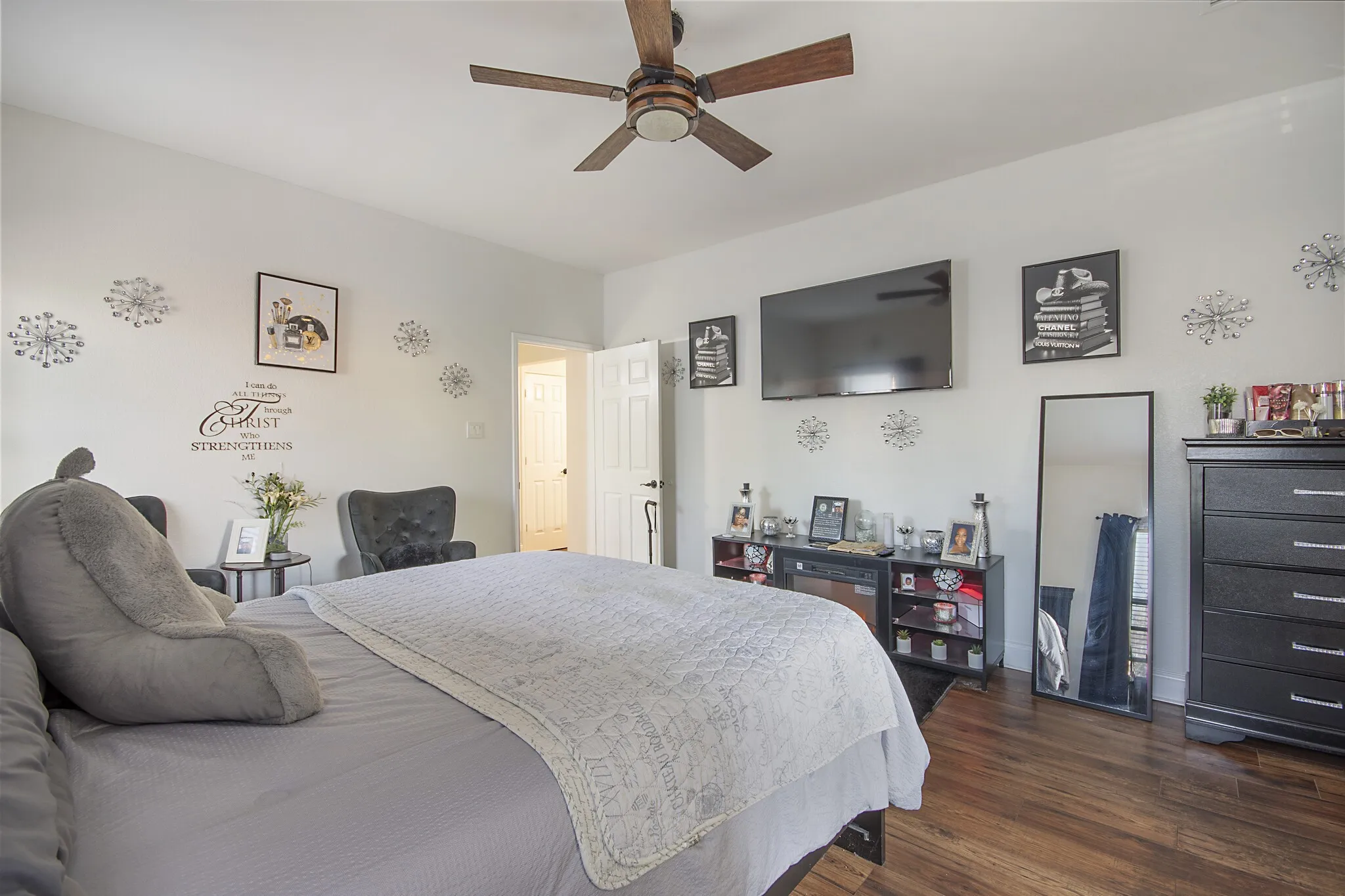 Bedroom with wood-look flooring and ceiling fan.