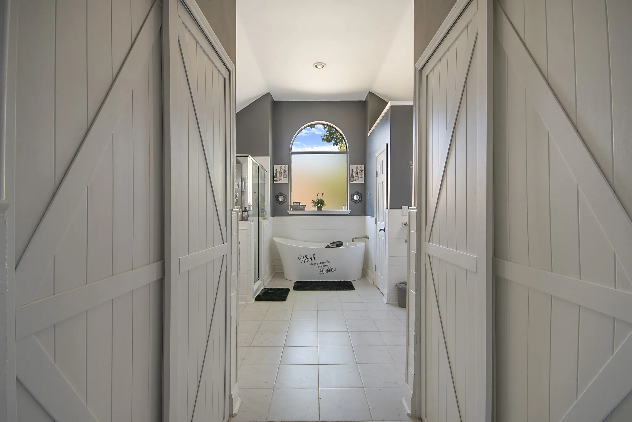 Double barn doors opening into the primary bath.