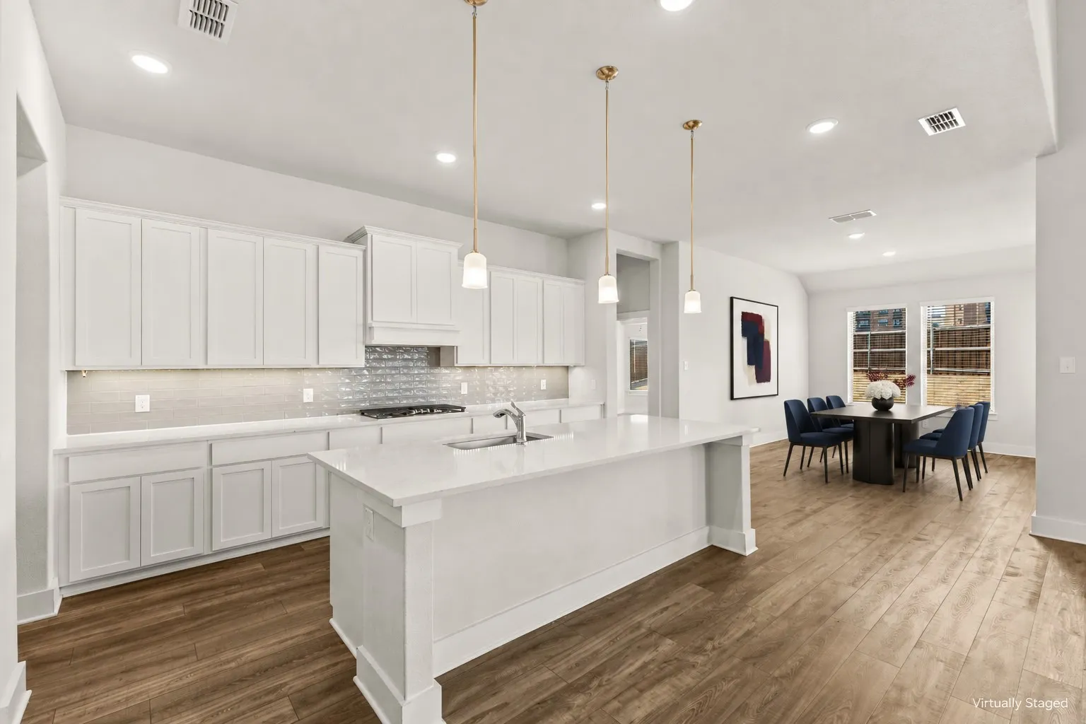 Kitchen featuring white cabinetry, a large center island, a subway tile backsplash, and wood-finish flooring