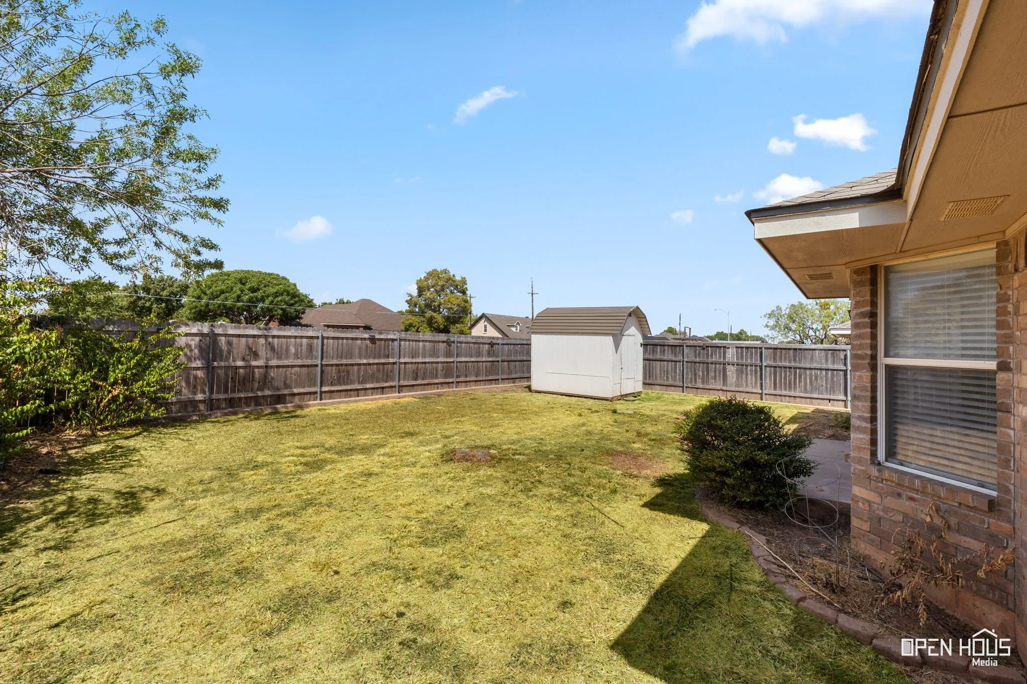 Backyard featuring a wood fence and an outdoor storage shed