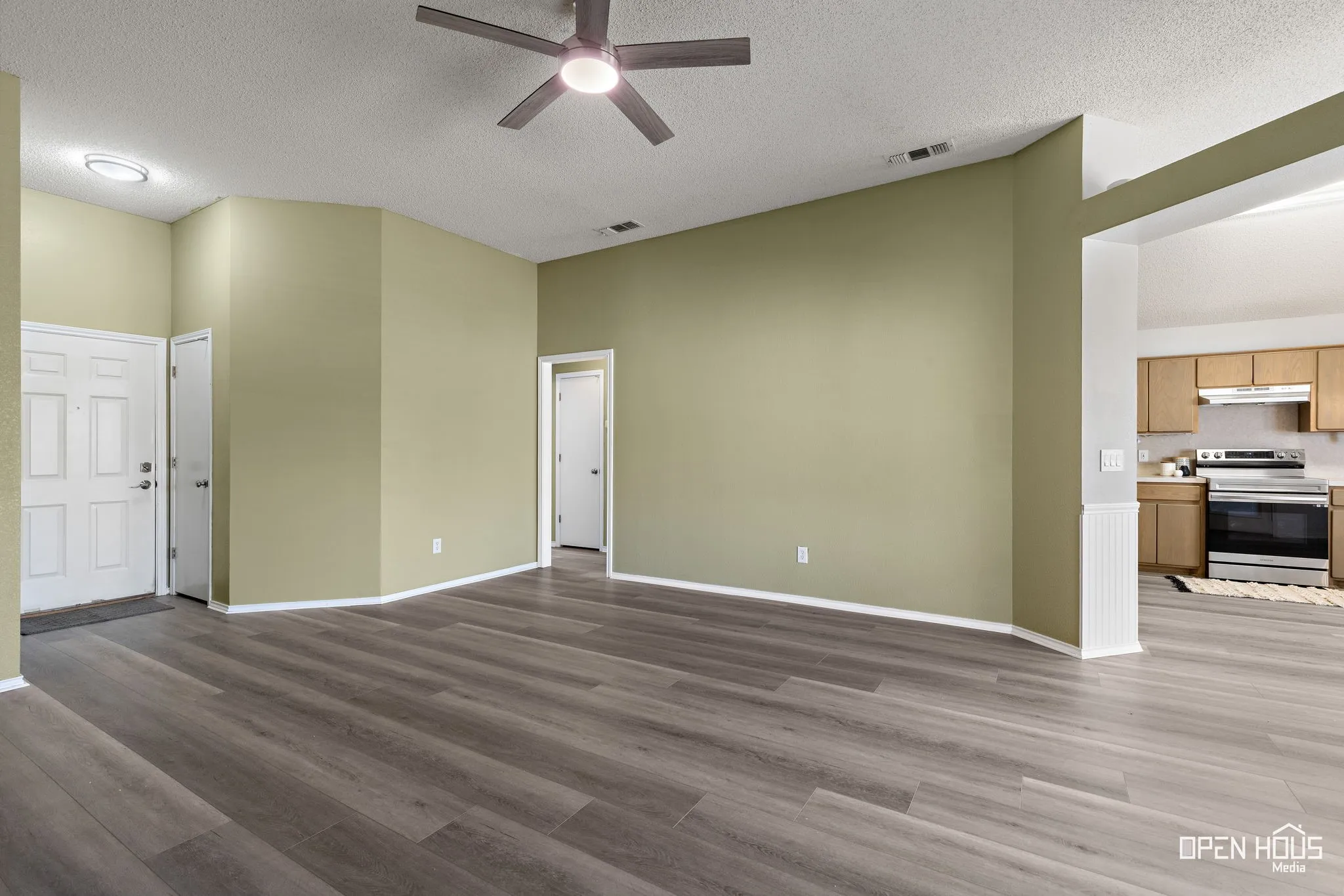 Wood-finish flooring throughout, ceiling fan with integrated lighting, and recessed ceiling lighting