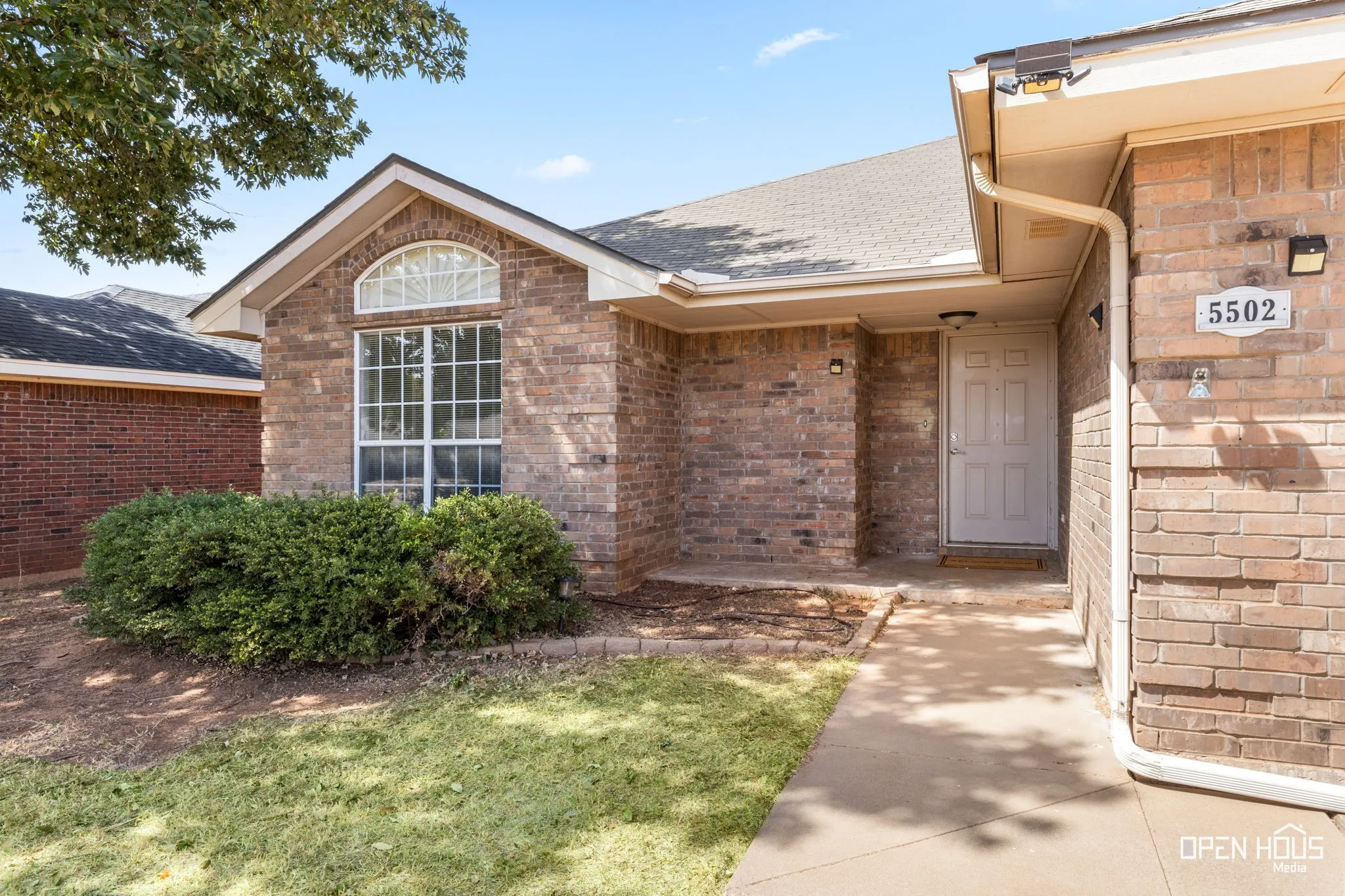 Brick exterior with white trim, arched window, and a gabled roof