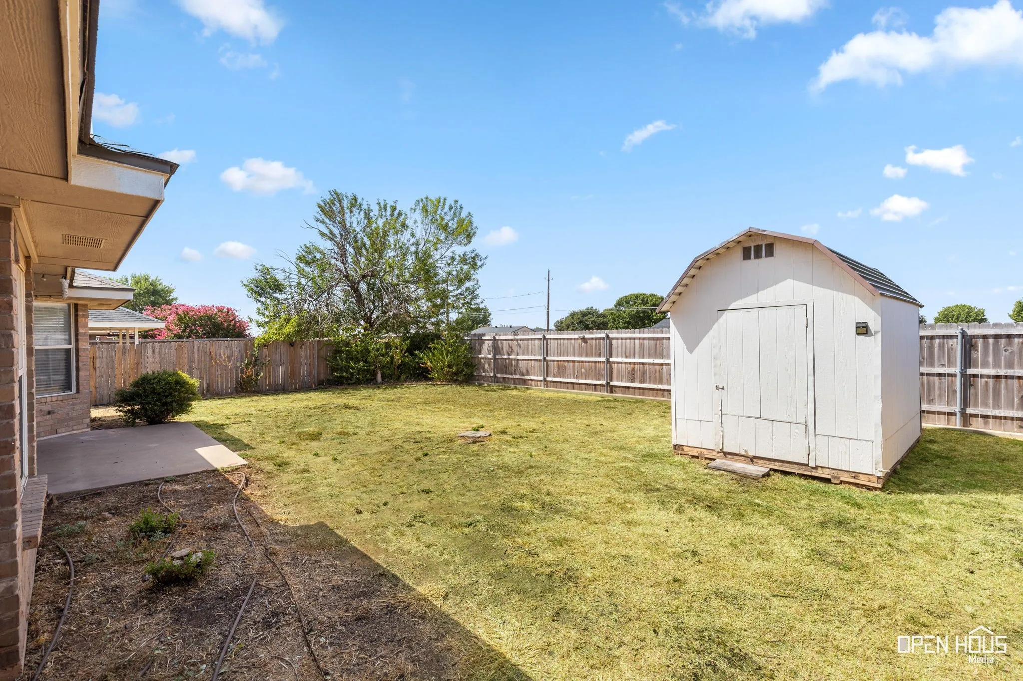 Backyard featuring a wood fence and an outdoor storage shed