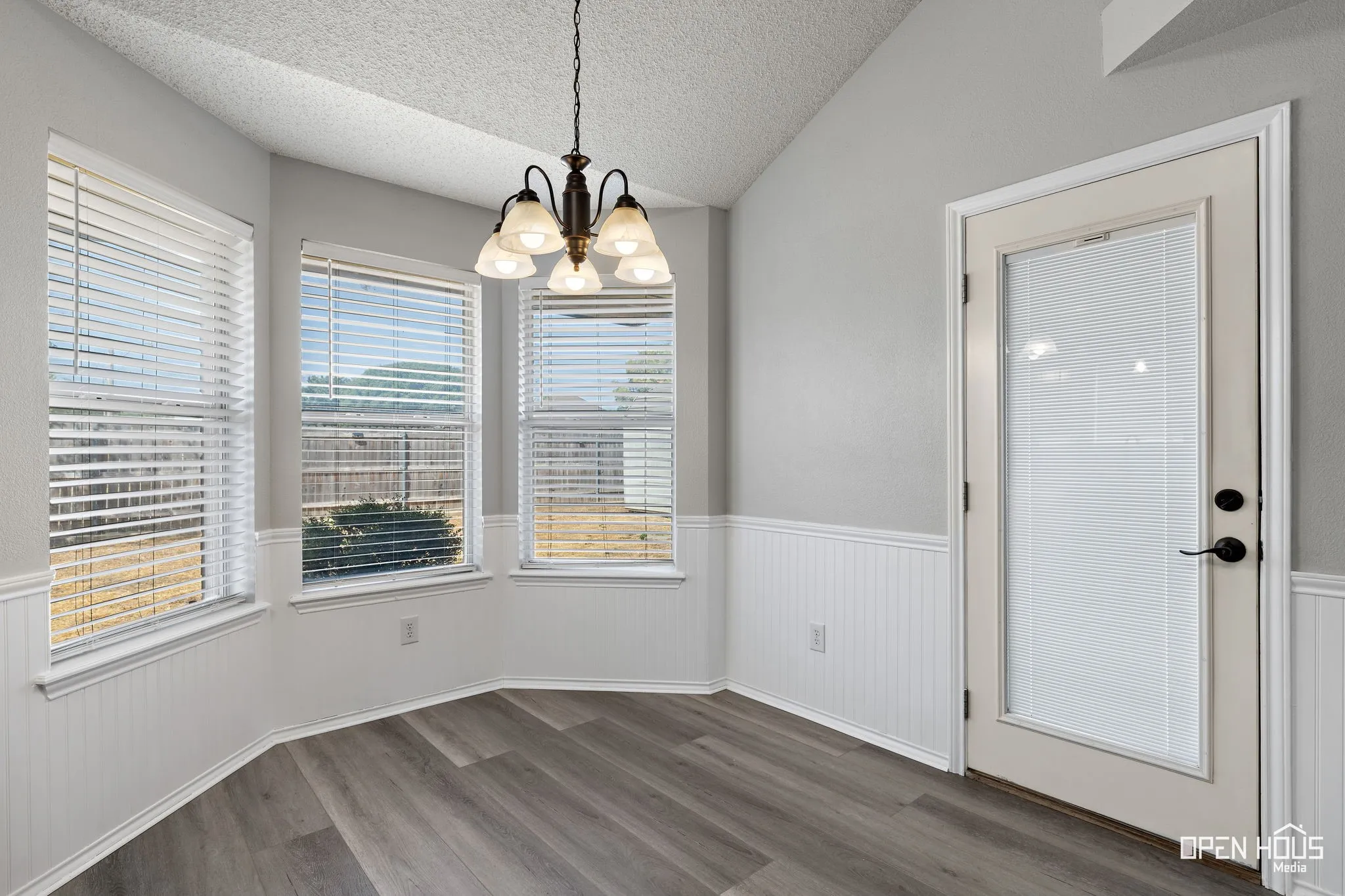 Wood-finish flooring, vaulted ceiling, and wainscoting detail