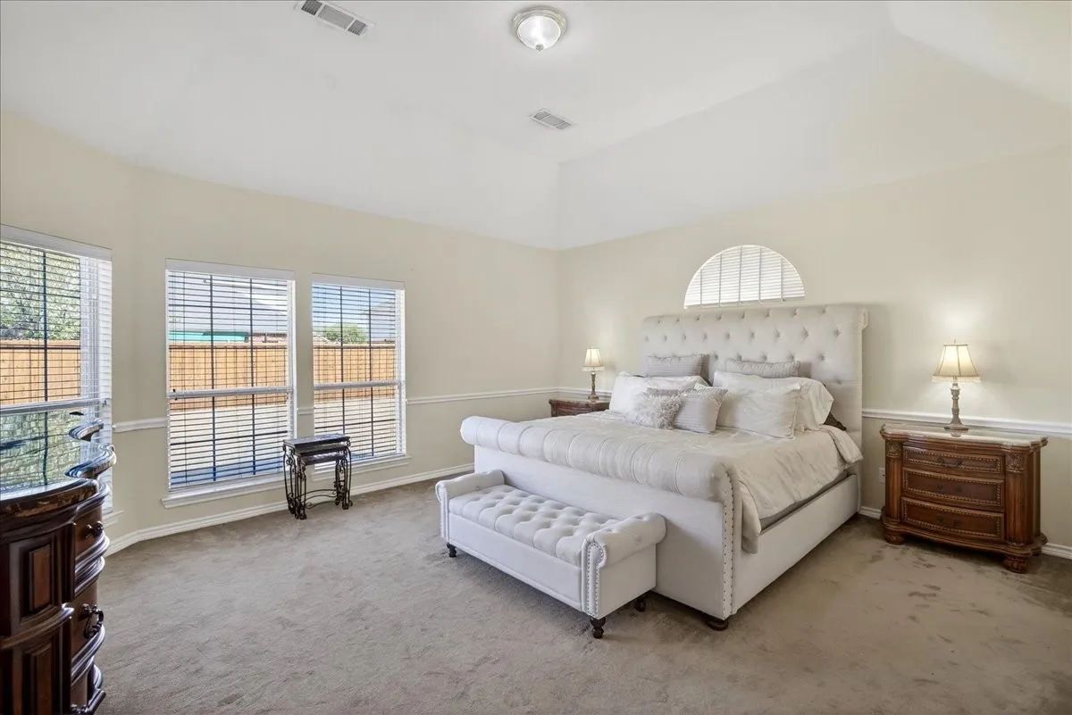 Primary bedroom located on the first floor with lots of natural light coming through from the row of windows.