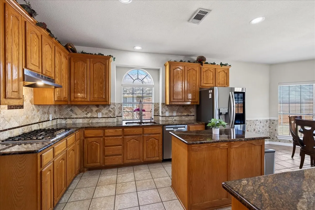 Spacious kitchen with an island, granite countertops, stainless style appliances and so much more.