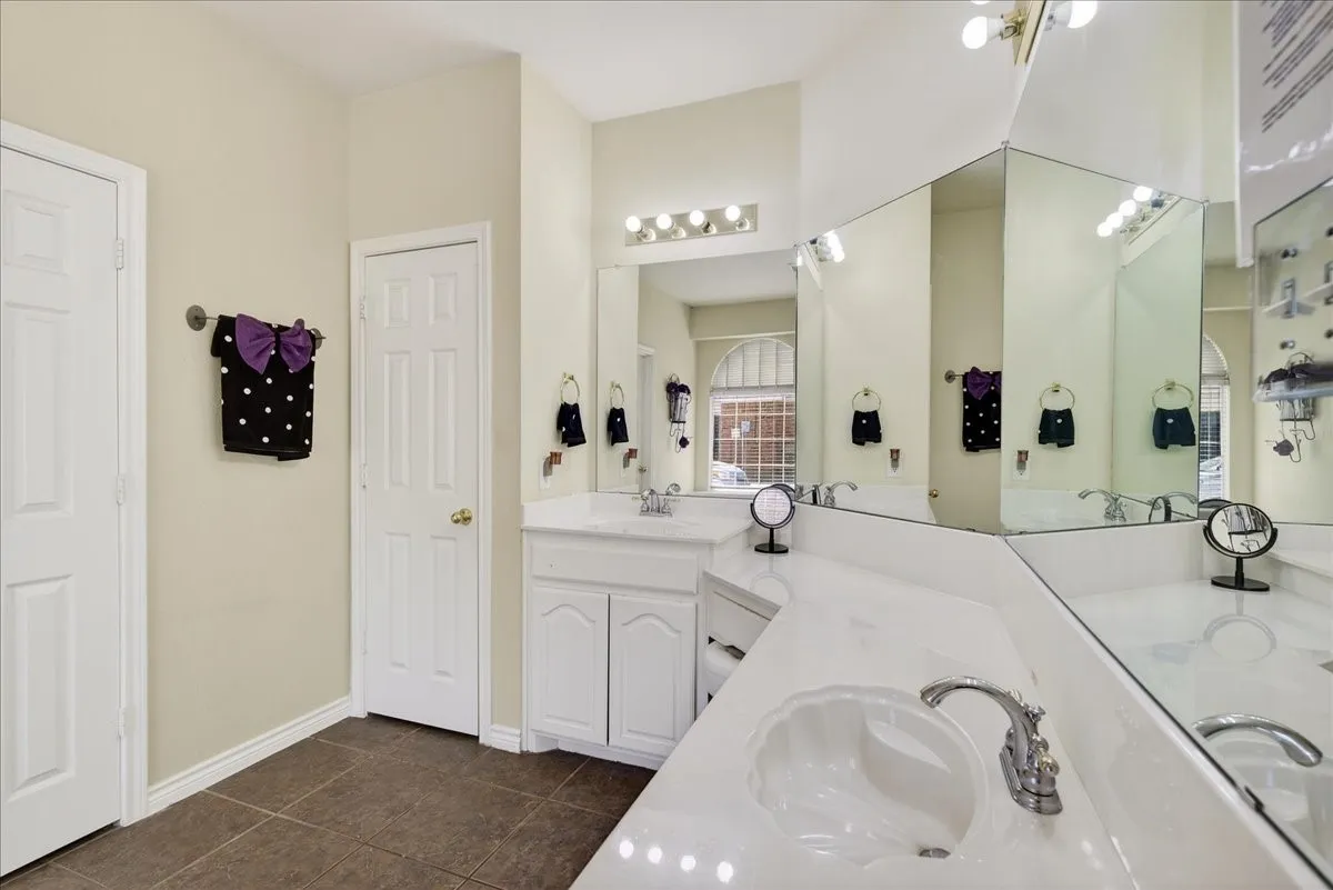 Another view of the primary bathroom with double sinks, garden tub, separate shower and walk in closet