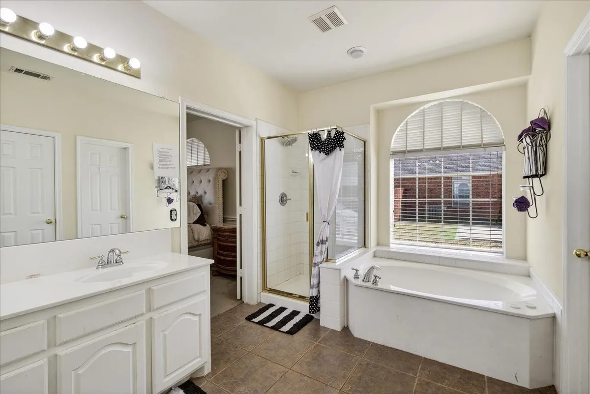 Primary bathroom with garden tub, separate shower and walk in closet.