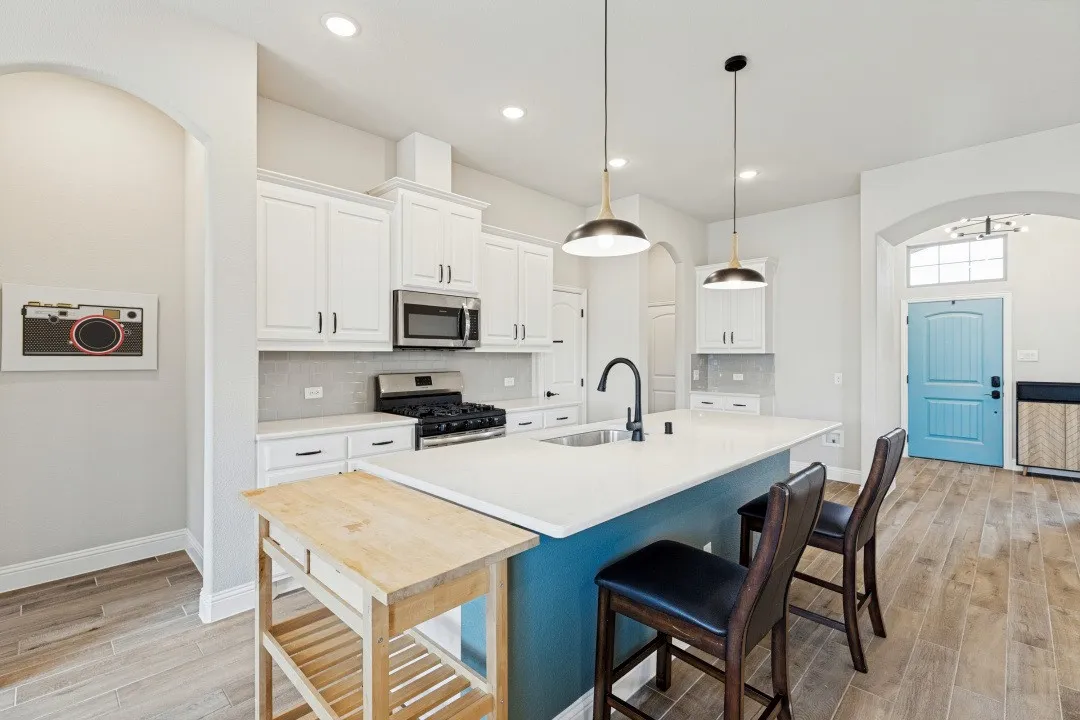 Quartz countertop, plenty of kitchen cabinets, recessed lighting throughout, and the cooktop has the exhaust fan that vents to the exterior