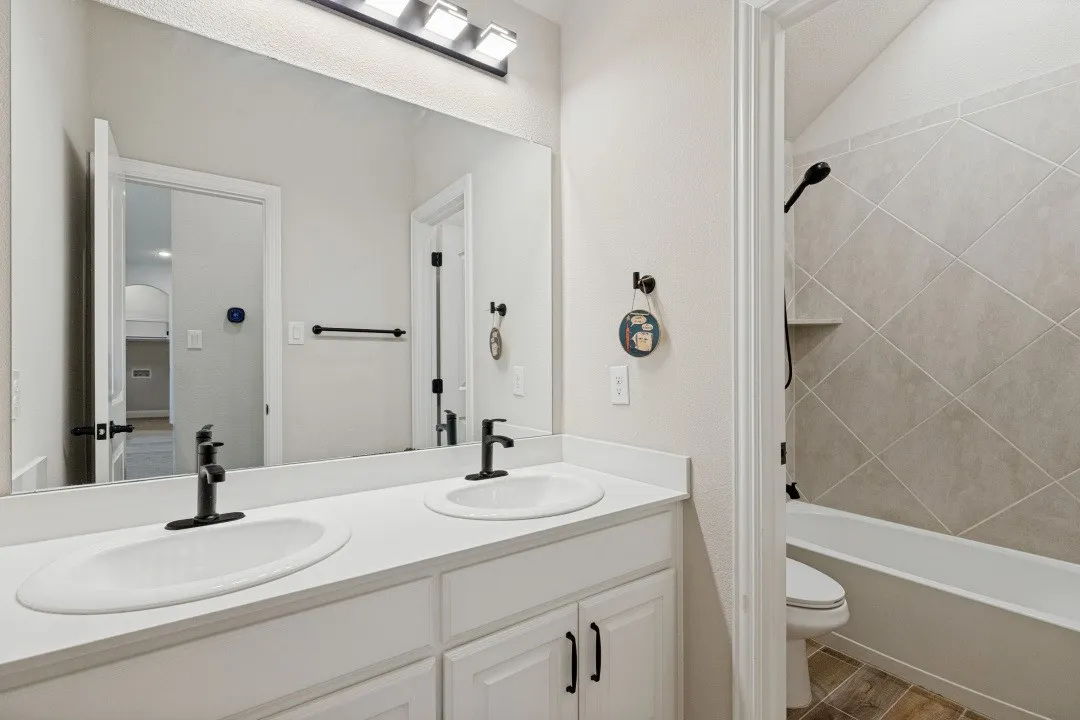 Dual vanity with white cabinetry and matte black faucets