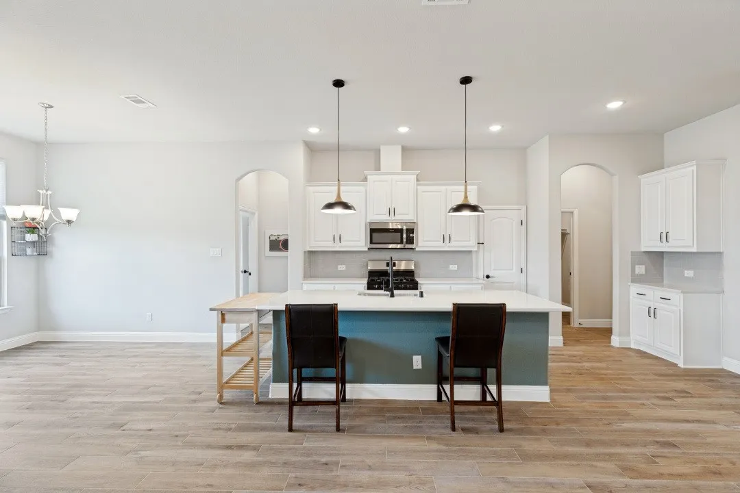 Stainless steel appliances with the exhaust hood that's vented to the exterior for cooking, quartz countertops, and the entire main area has the porcelain tile plank flooring easy to maintain and almost impossible to stain