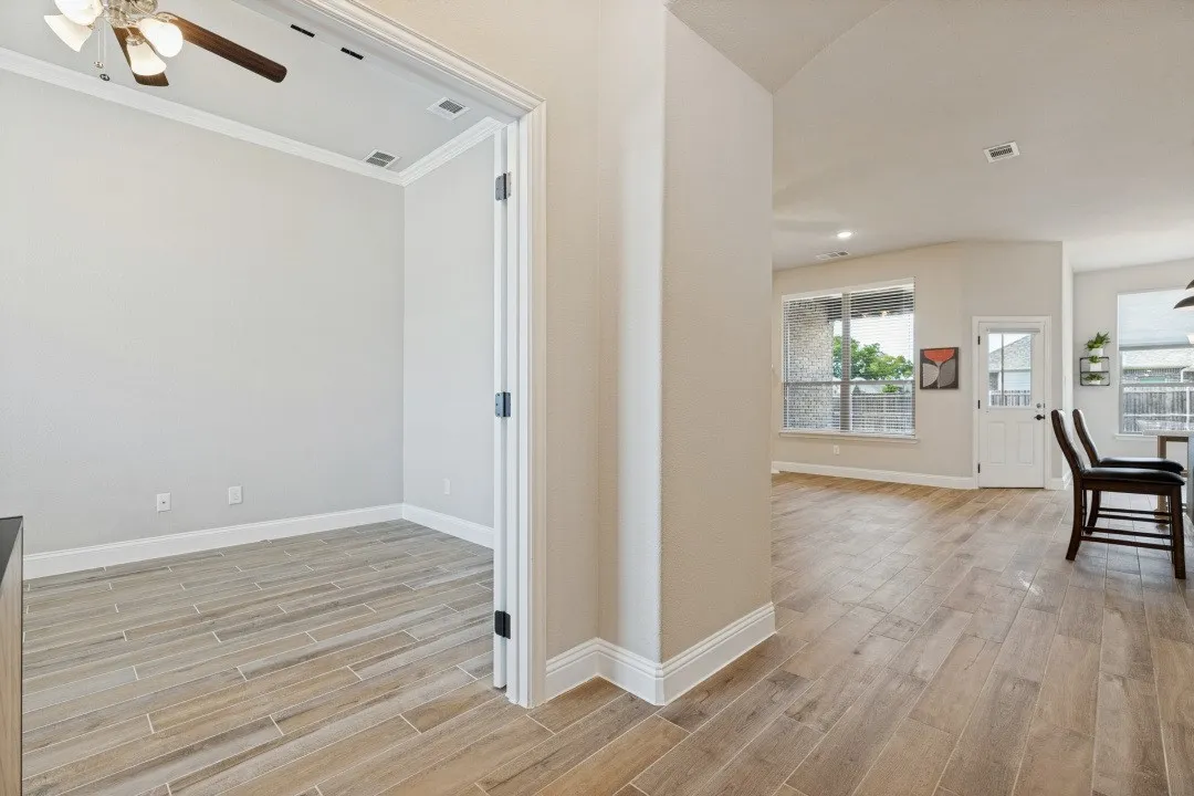 Wood-look tile flooring extending through main areas, recessed lighting, and crown molding