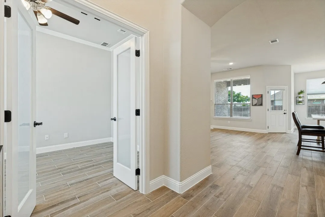 Glass panels on the French doors to the study, plus porcelain ceramic wood-look tile throughout. This is the most expensive flooring that there is today and it's just unbelievably resilient with kids and pets