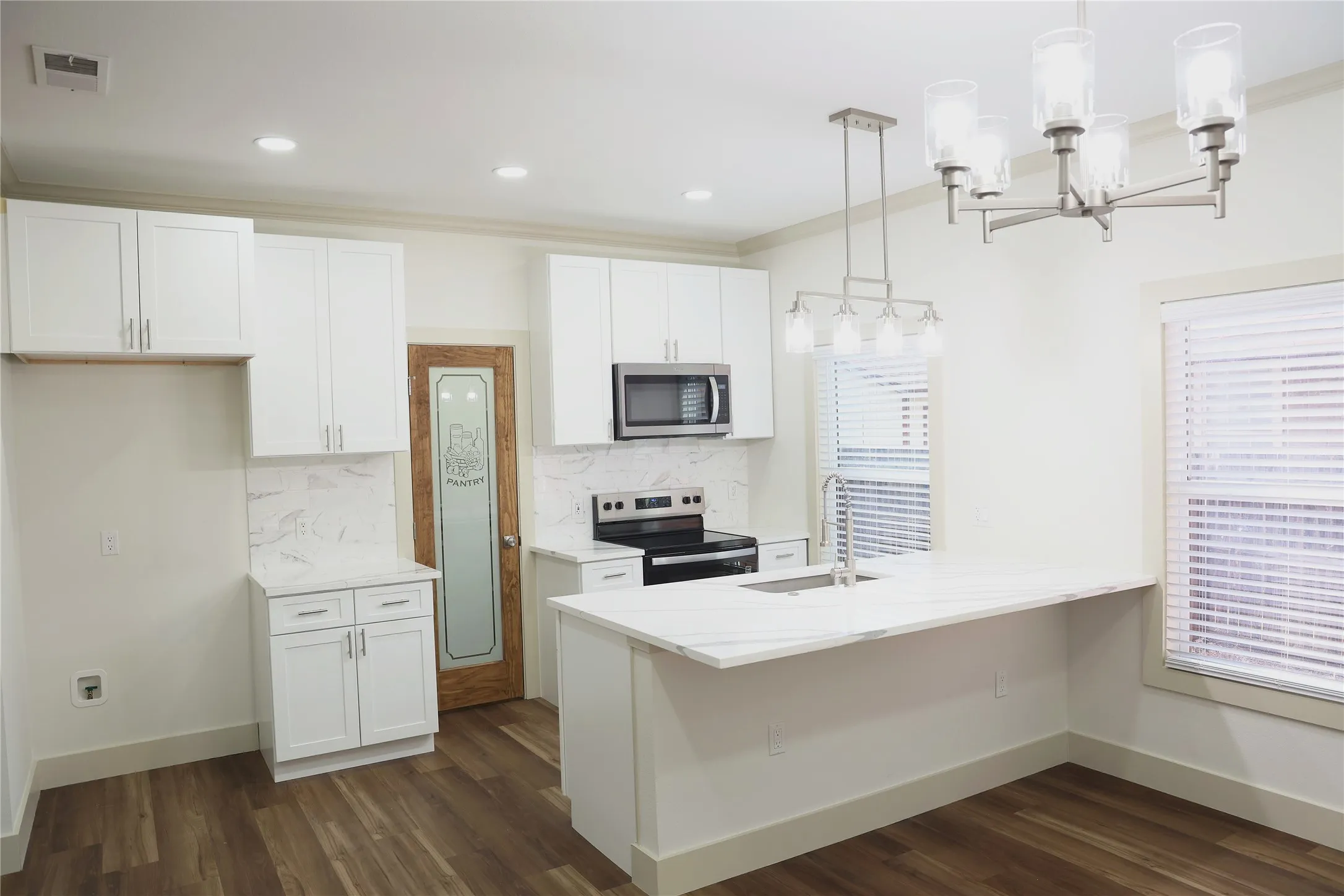 Modern kitchen featuring white cabinetry, stone-finish countertops, stainless steel appliances, wood-finish flooring, and recessed lighting