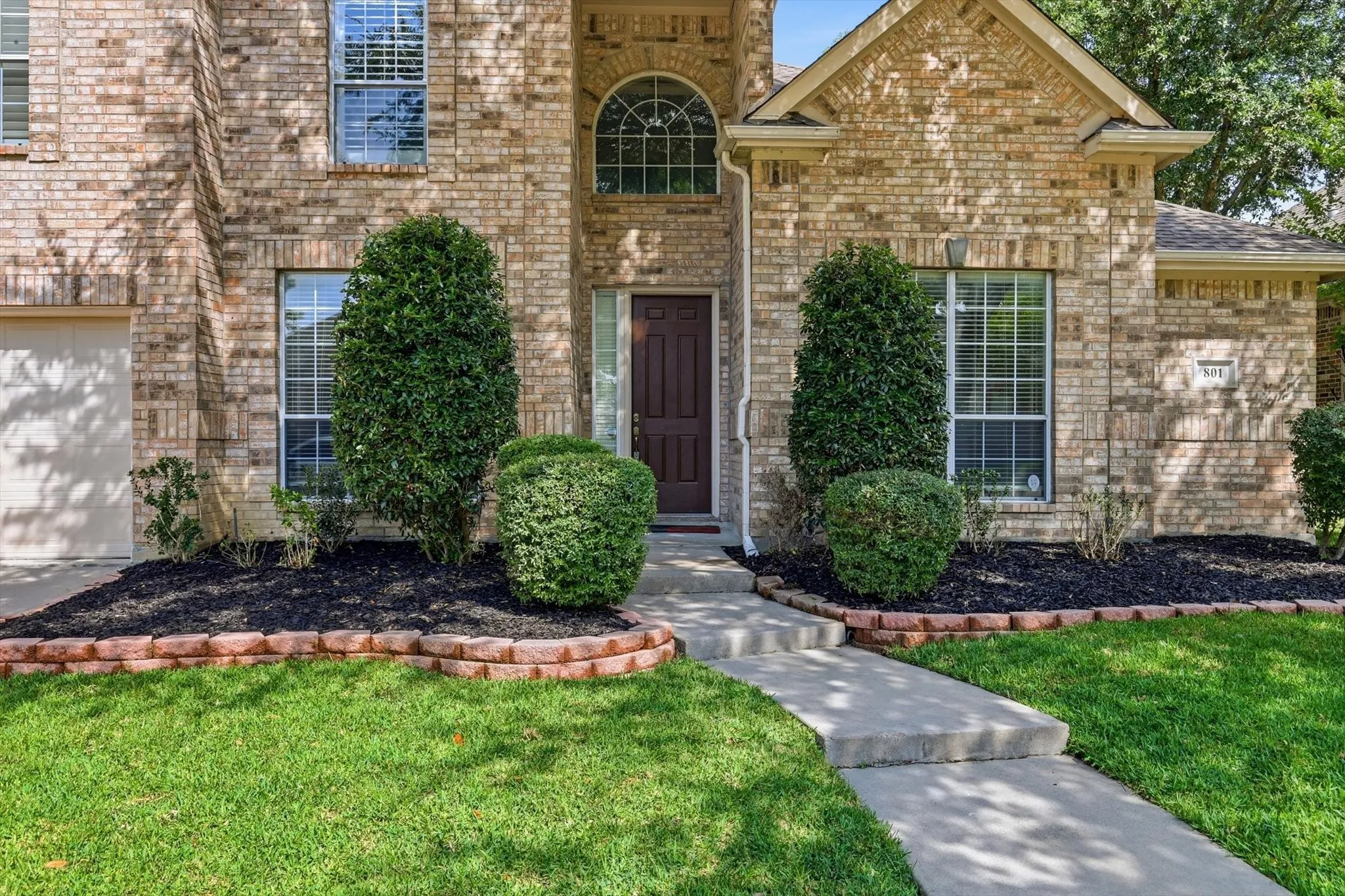 Brick exterior featuring a gabled roofline, arched entry window