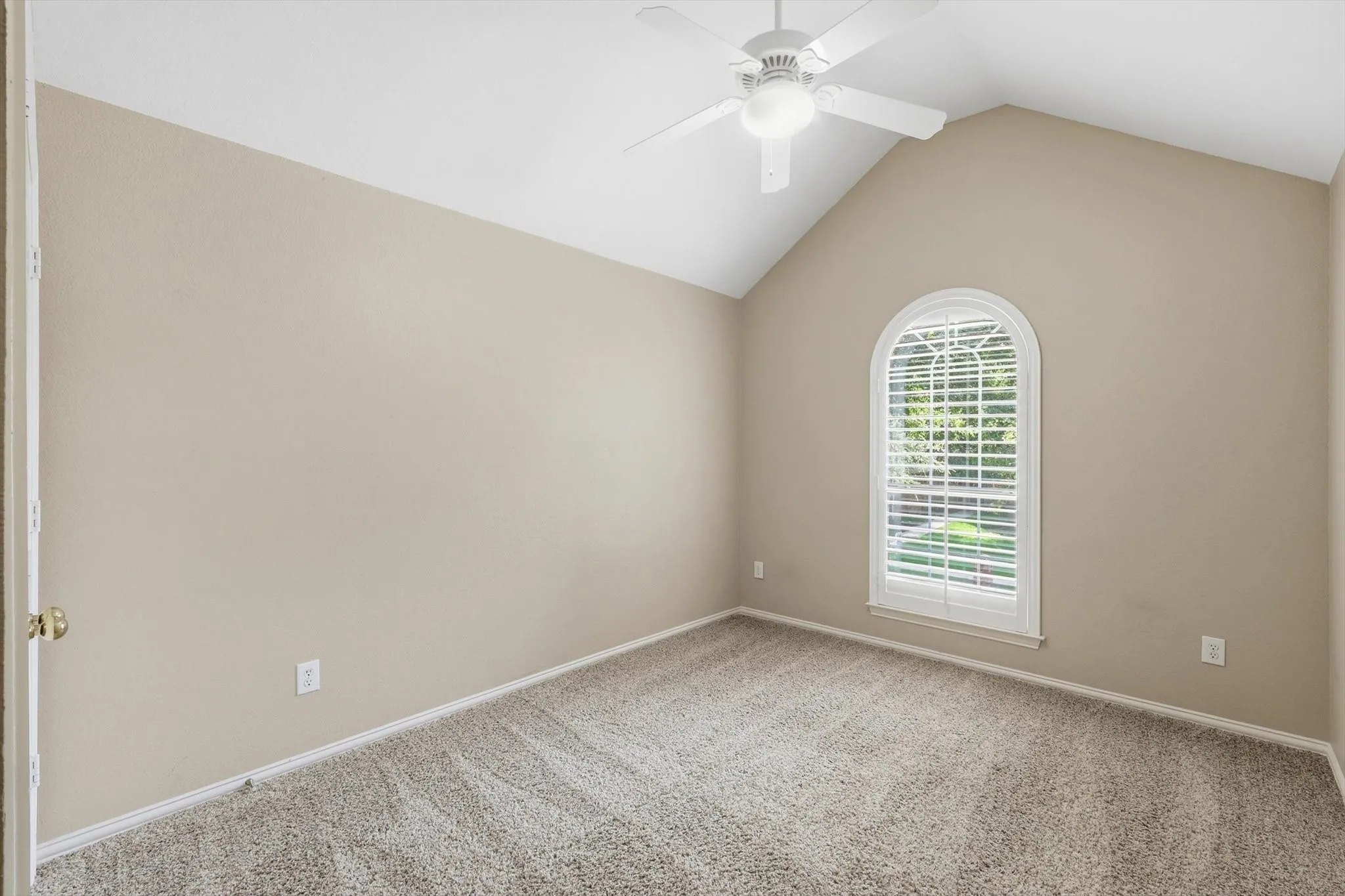 Upstairs bedroom two featuring a vaulted ceiling, with plantation shutters, and a ceiling fan