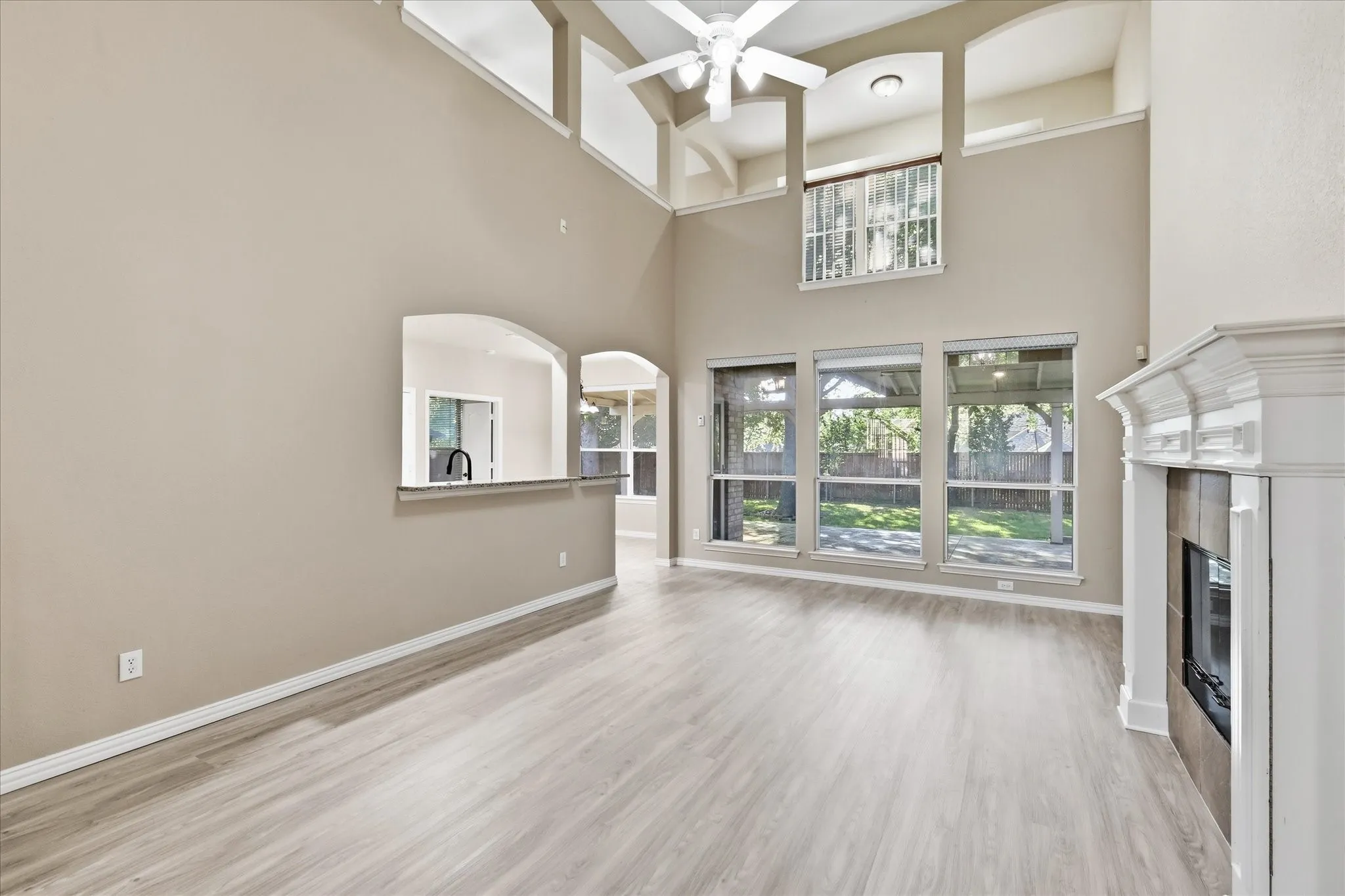 High ceiling family room with brand new Luxury vinyl flooring installed Aug 2026, decorative mantle fir place