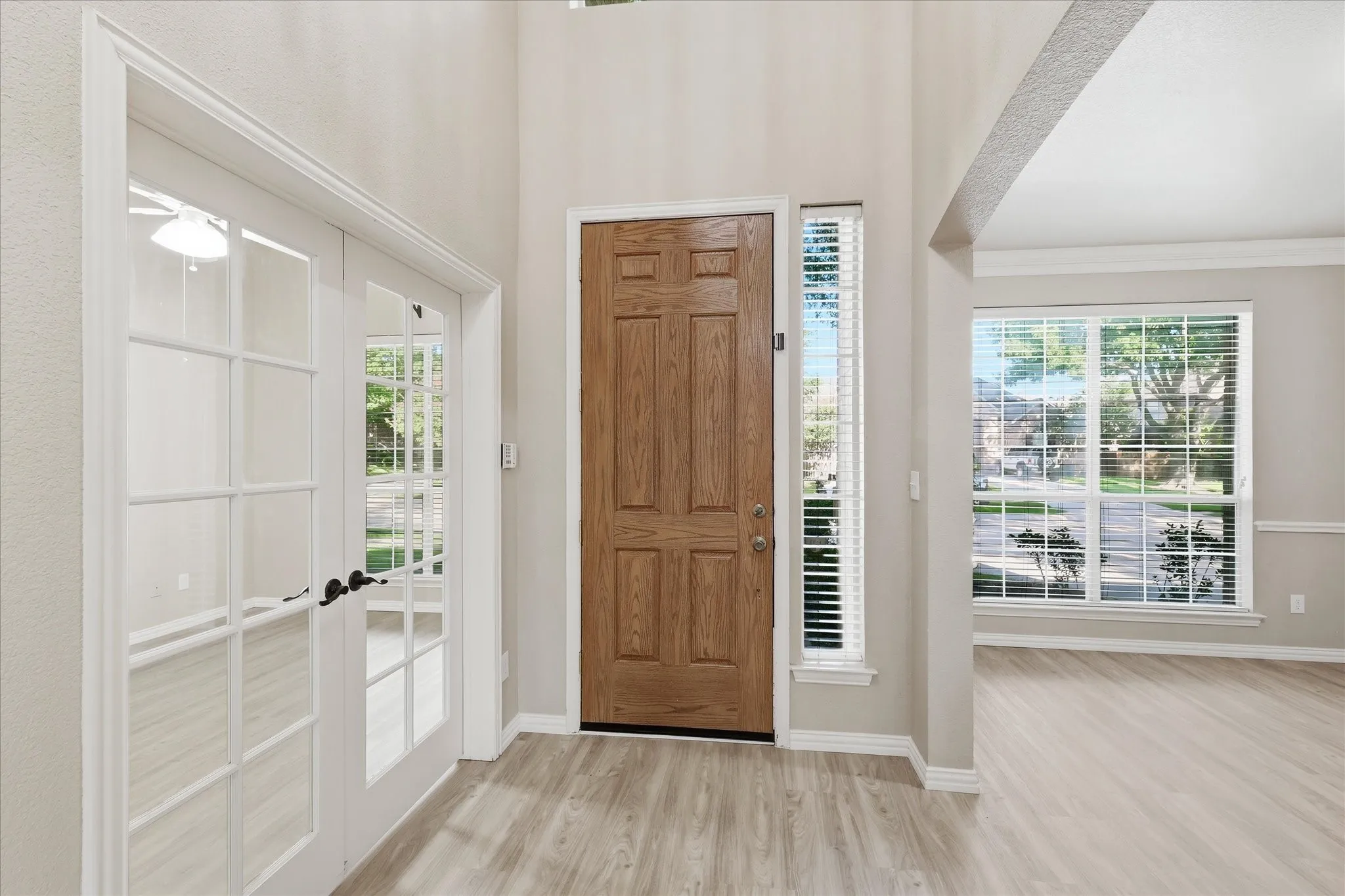 Looking at the front door with the office room on left with French door, formal dining on right