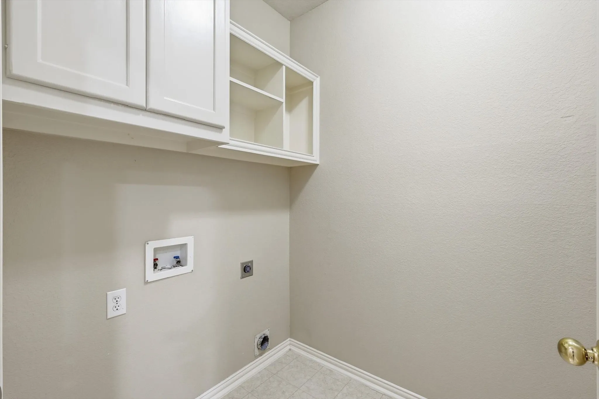 Laundry area featuring overhead white cabinetry with open shelving and closed storage