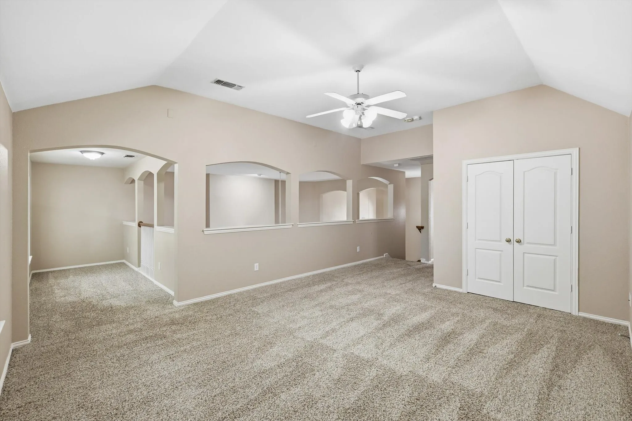 Upstairs flex space with ceiling fan. This can be used as a family room or a game room looking down to the high ceiling living room with arched structures