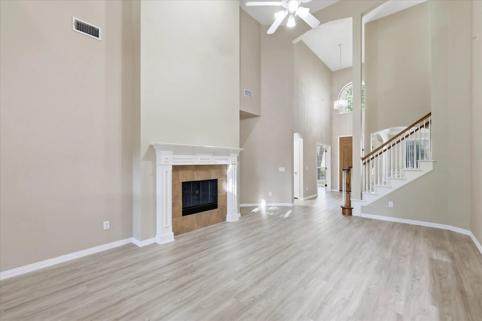 Two story high ceiling living room with ceiling fan and brand new luxury vinyl floor installed Aug 2026