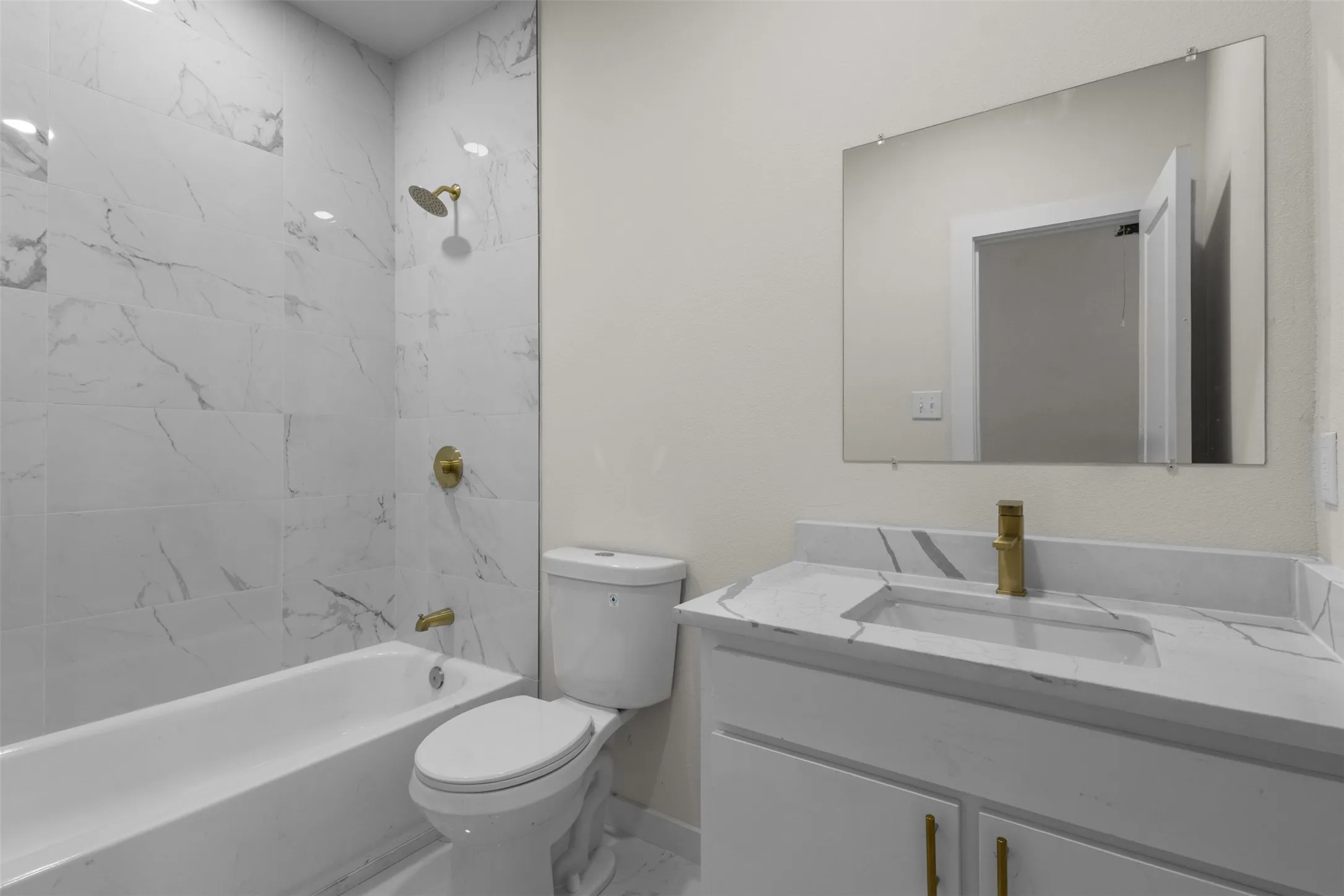 White vanity with integrated sink and gold-tone faucet