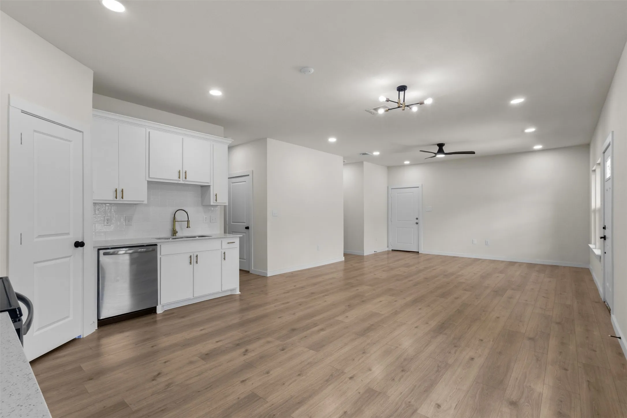 Open-concept living space with wood-finish flooring, recessed lighting, and a modern ceiling fan