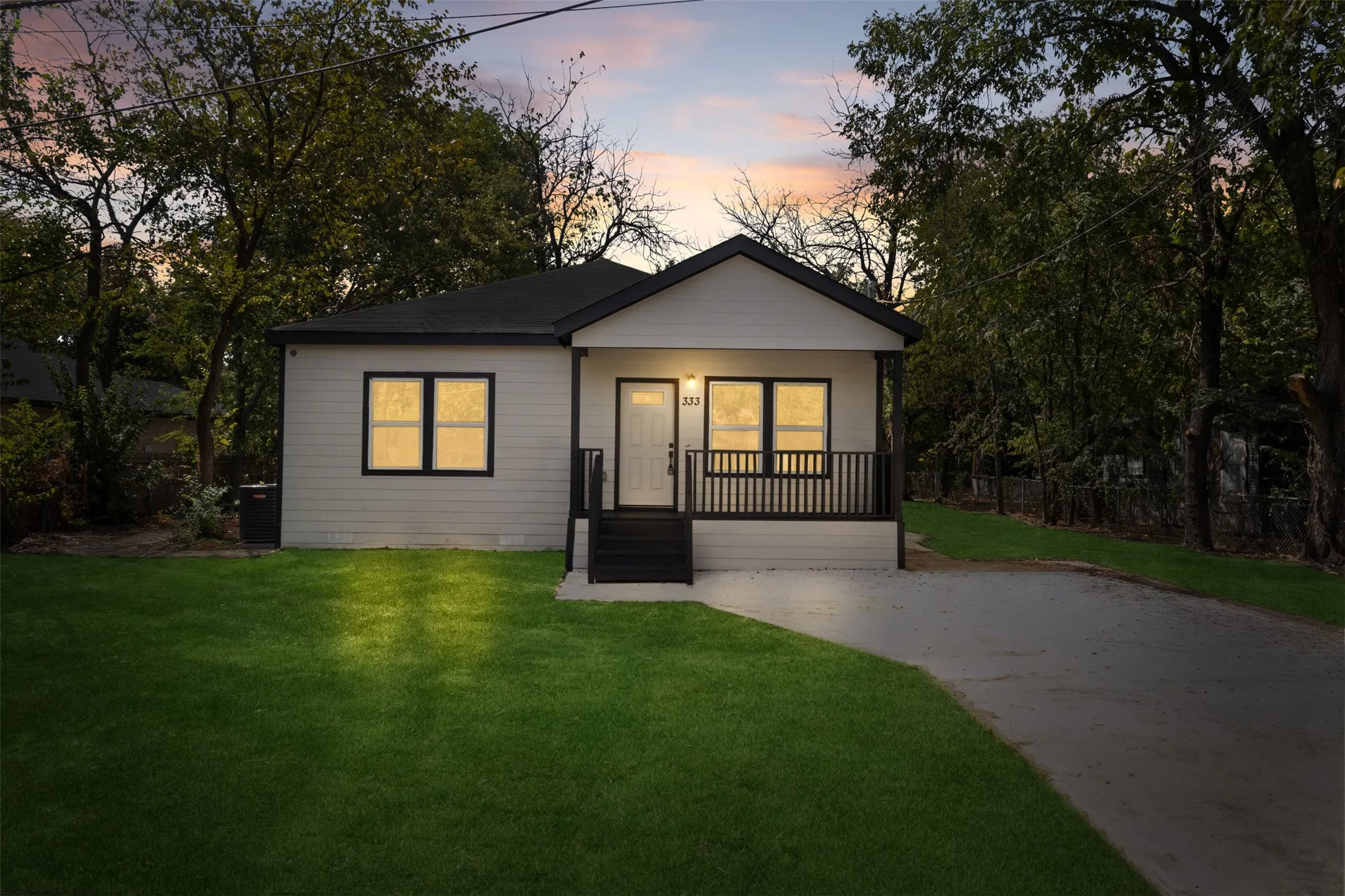Contemporary single-story residence with a black-trimmed roofline and light-colored siding