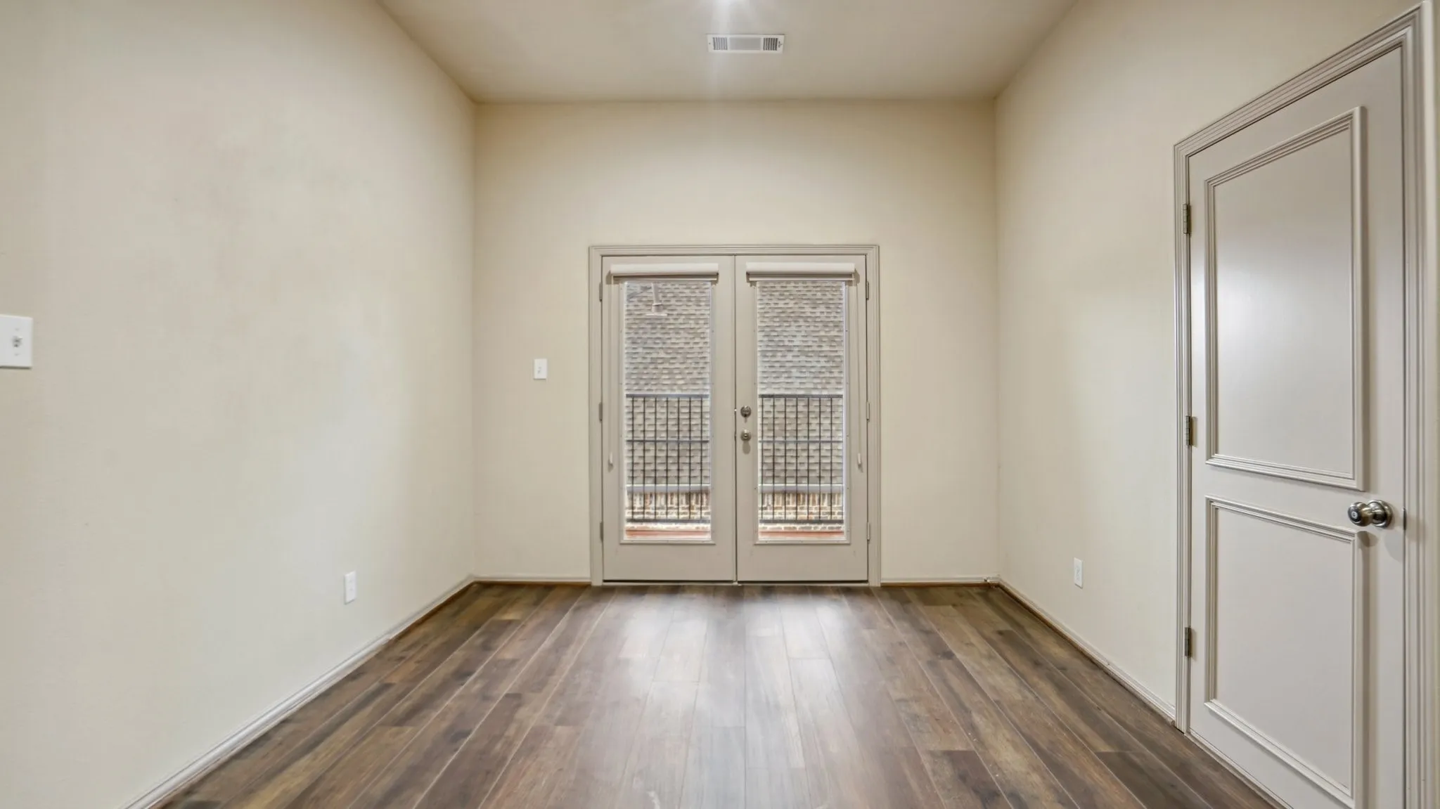 Unfurnished room featuring french doors, dark wood-type flooring, and visible vents