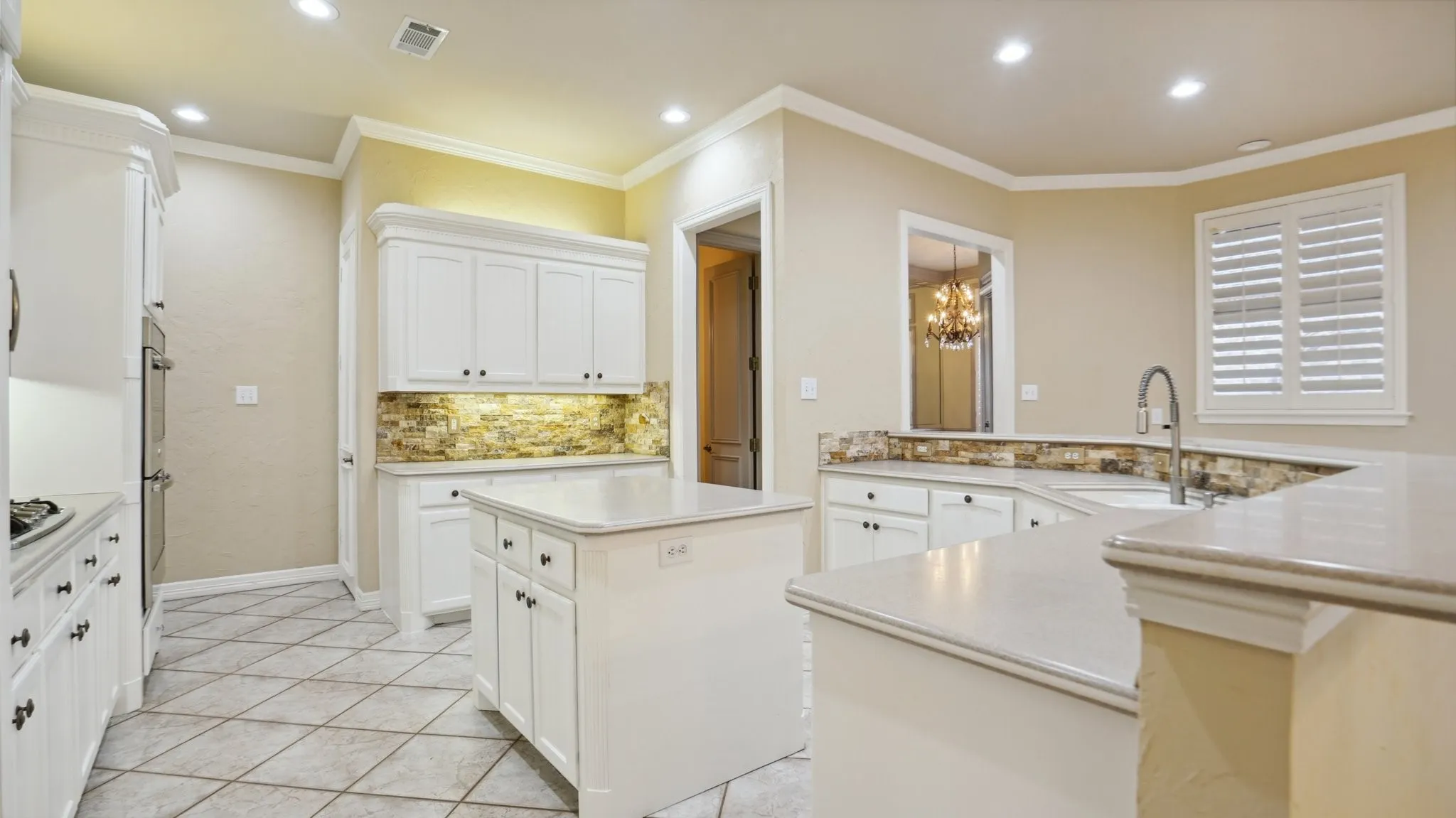 Kitchen featuring a kitchen island, recessed lighting, decorative backsplash, and a sink
