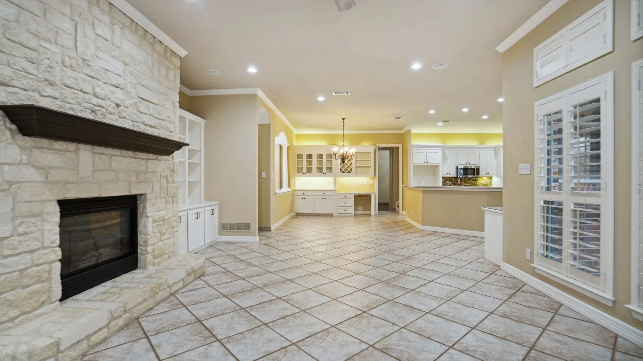 Unfurnished living room featuring crown molding, a fireplace, baseboards, recessed lighting, and light tile patterned floors
