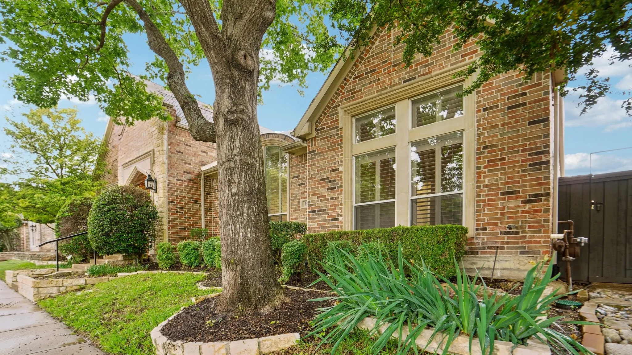 View of home's exterior featuring brick siding and fence
