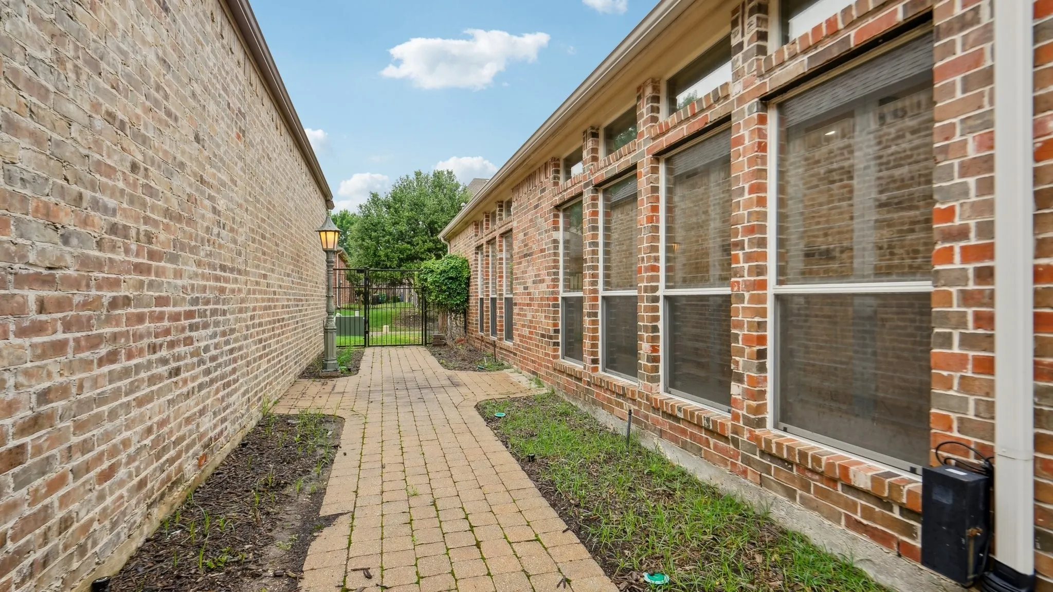 View of home's exterior with brick siding and fence