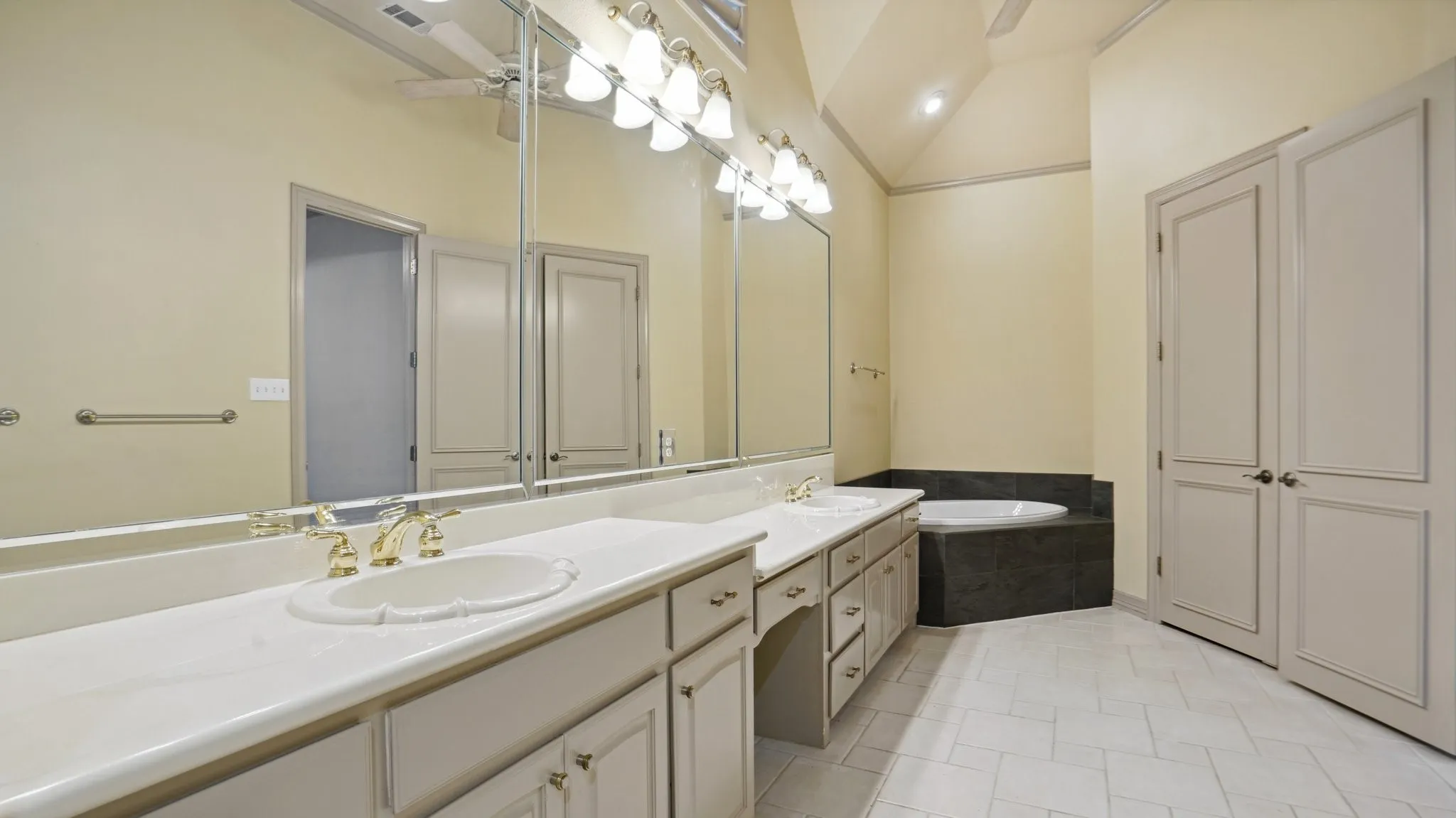 Bathroom with a sink, a bath, tile patterned flooring, and double vanity
