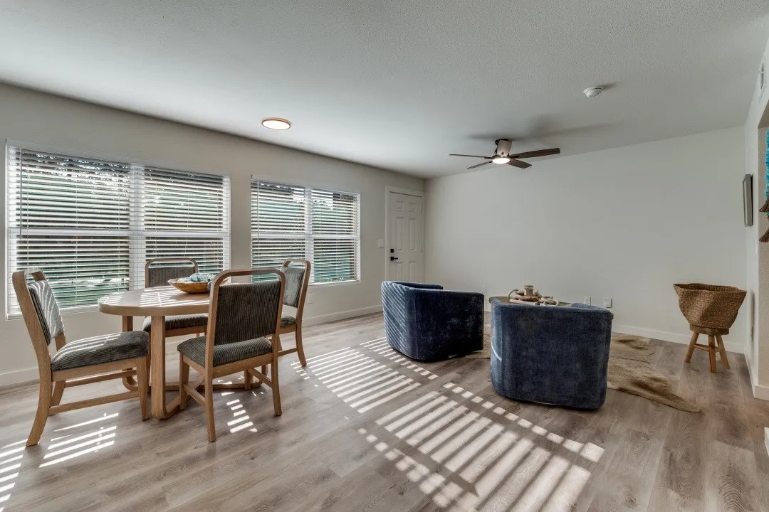 Recessed lighting, wood-finish flooring, multiple windows with blinds, ceiling fan, and white walls