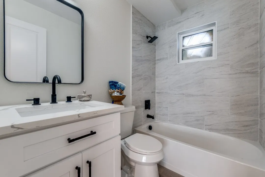 White vanity with a solid surface countertop and integrated rectangular sink