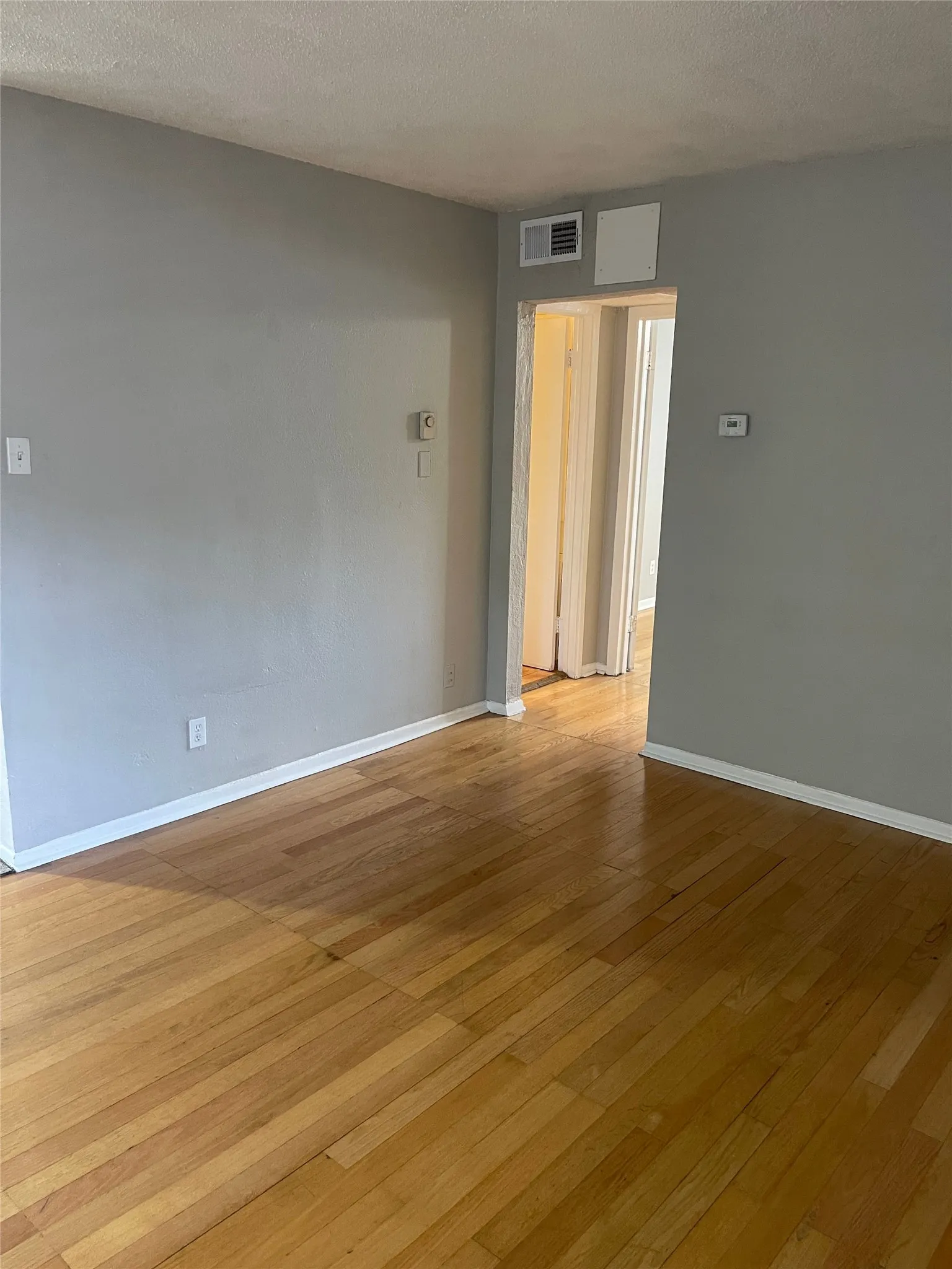 Wood-finish flooring with white trim and light gray walls